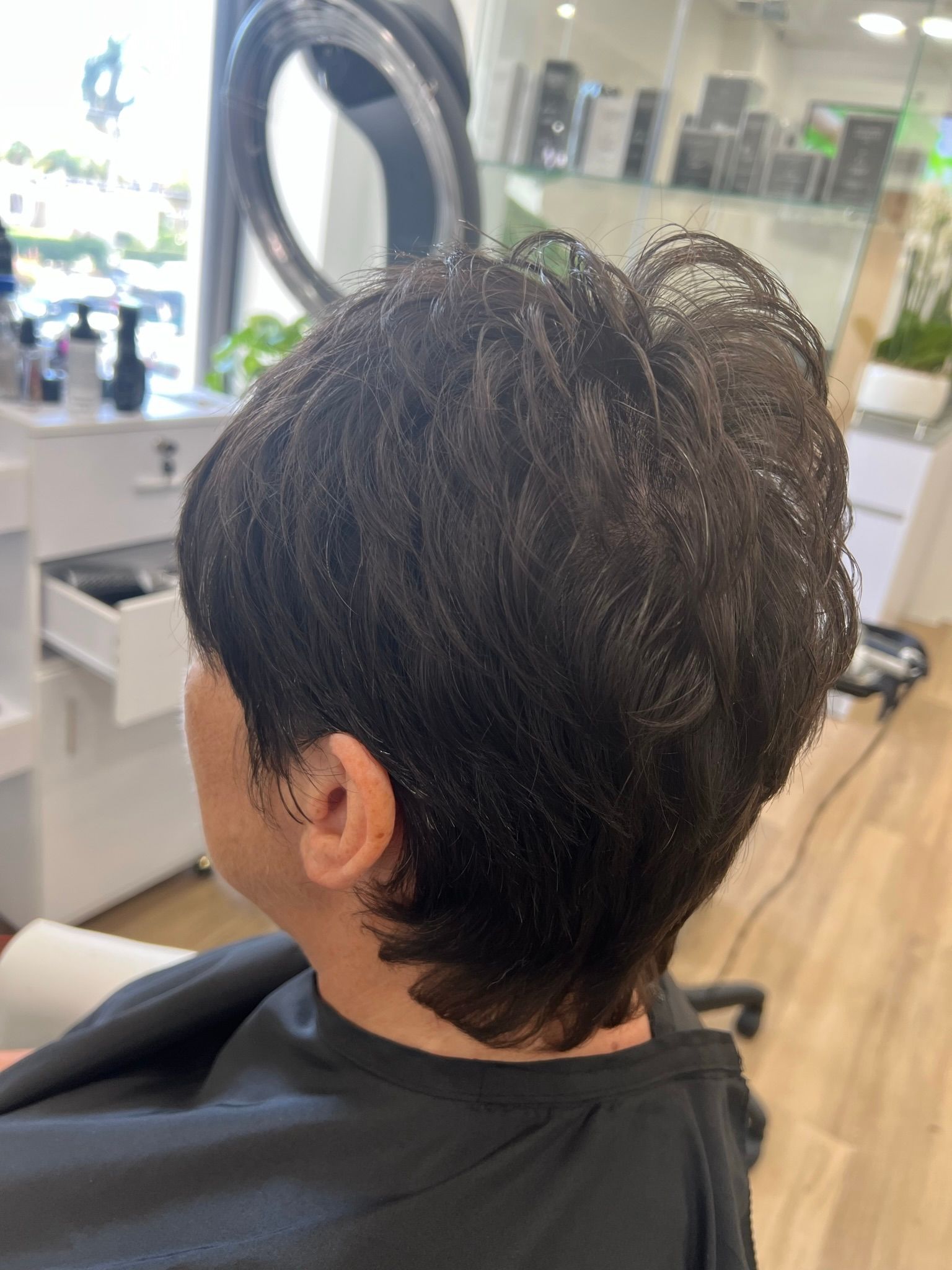 A man is getting his hair cut in a salon.