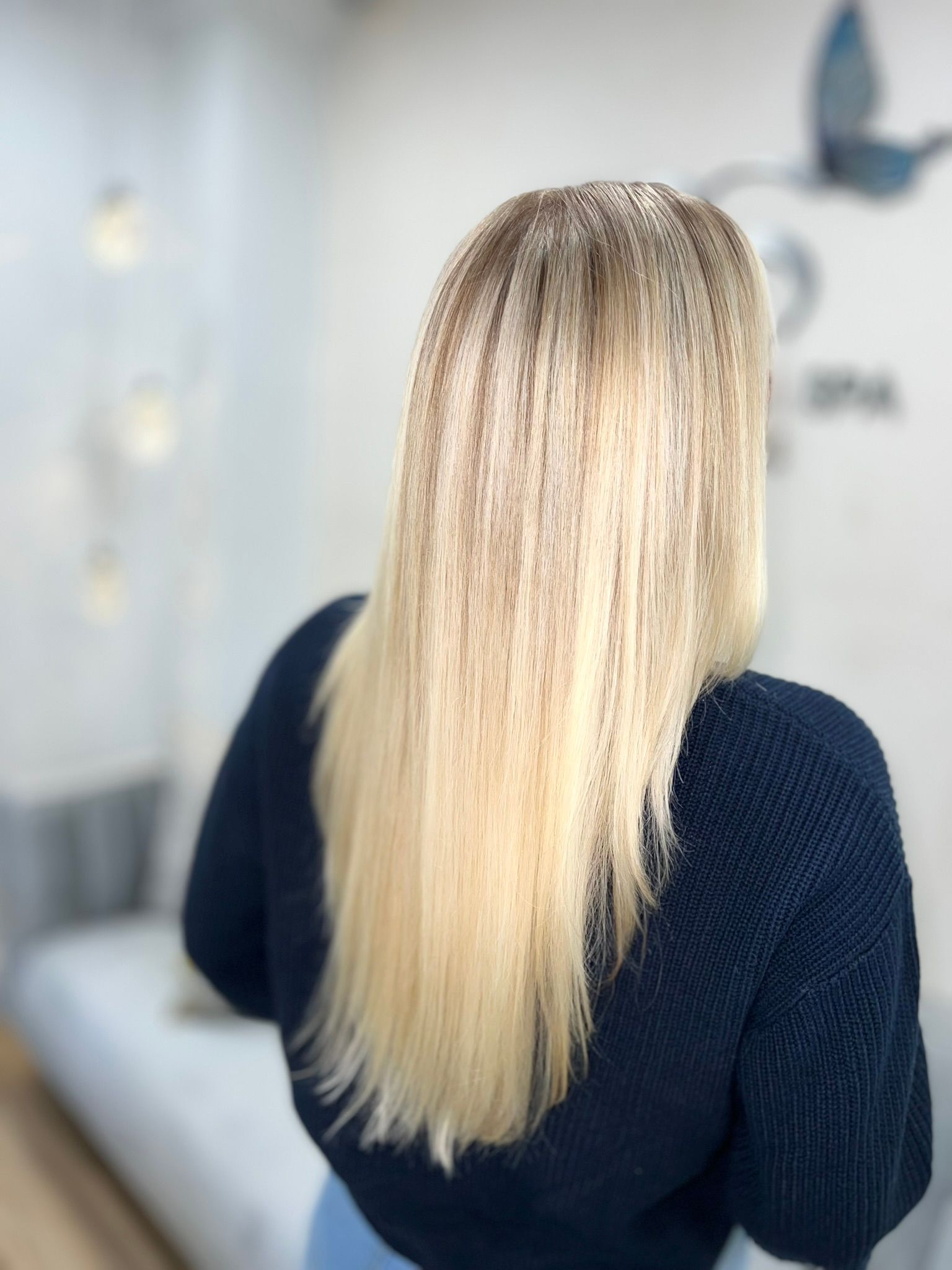 A woman with blonde hair is wearing a black sweater