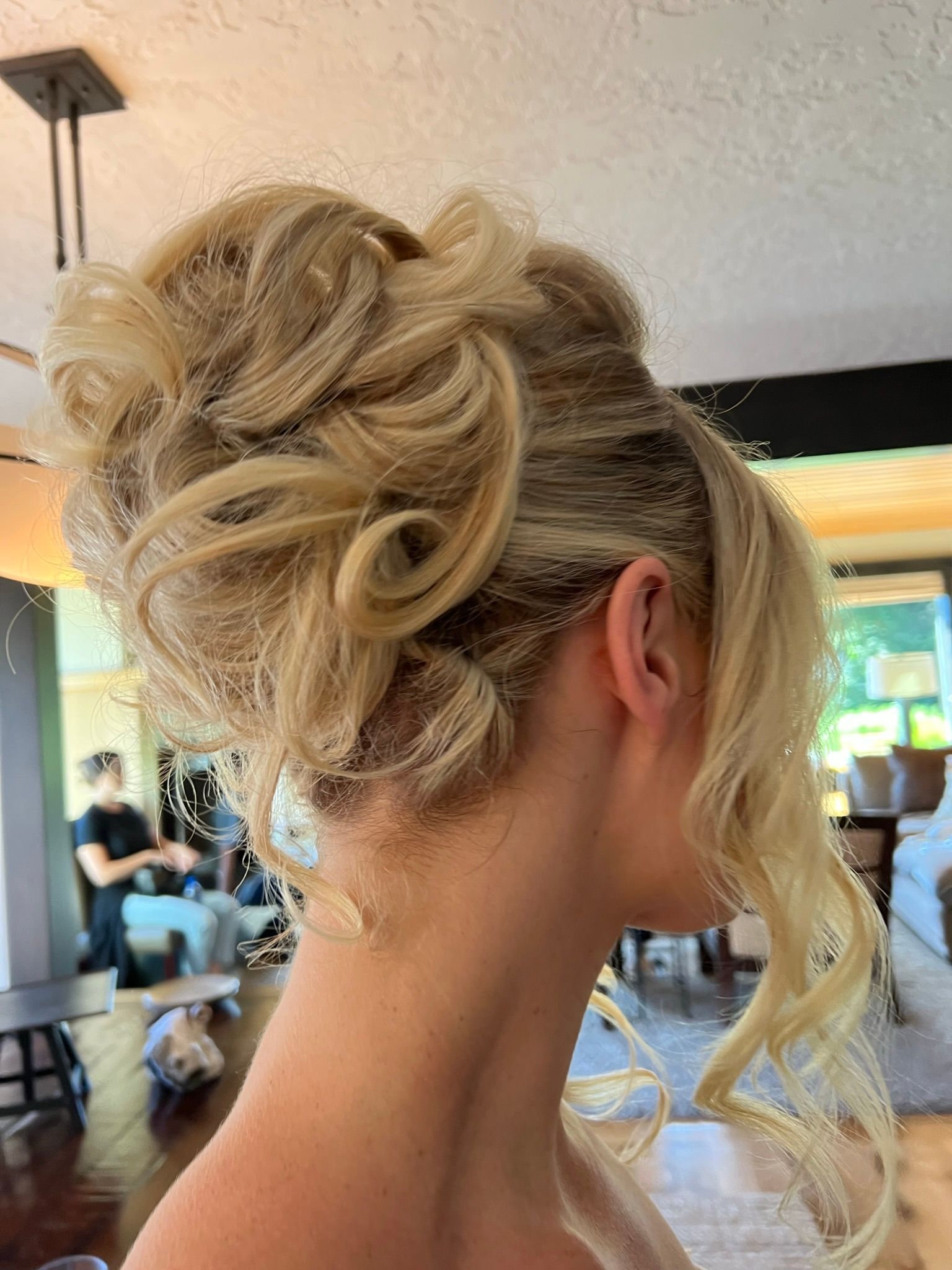 A woman is wearing her hair in a messy bun.