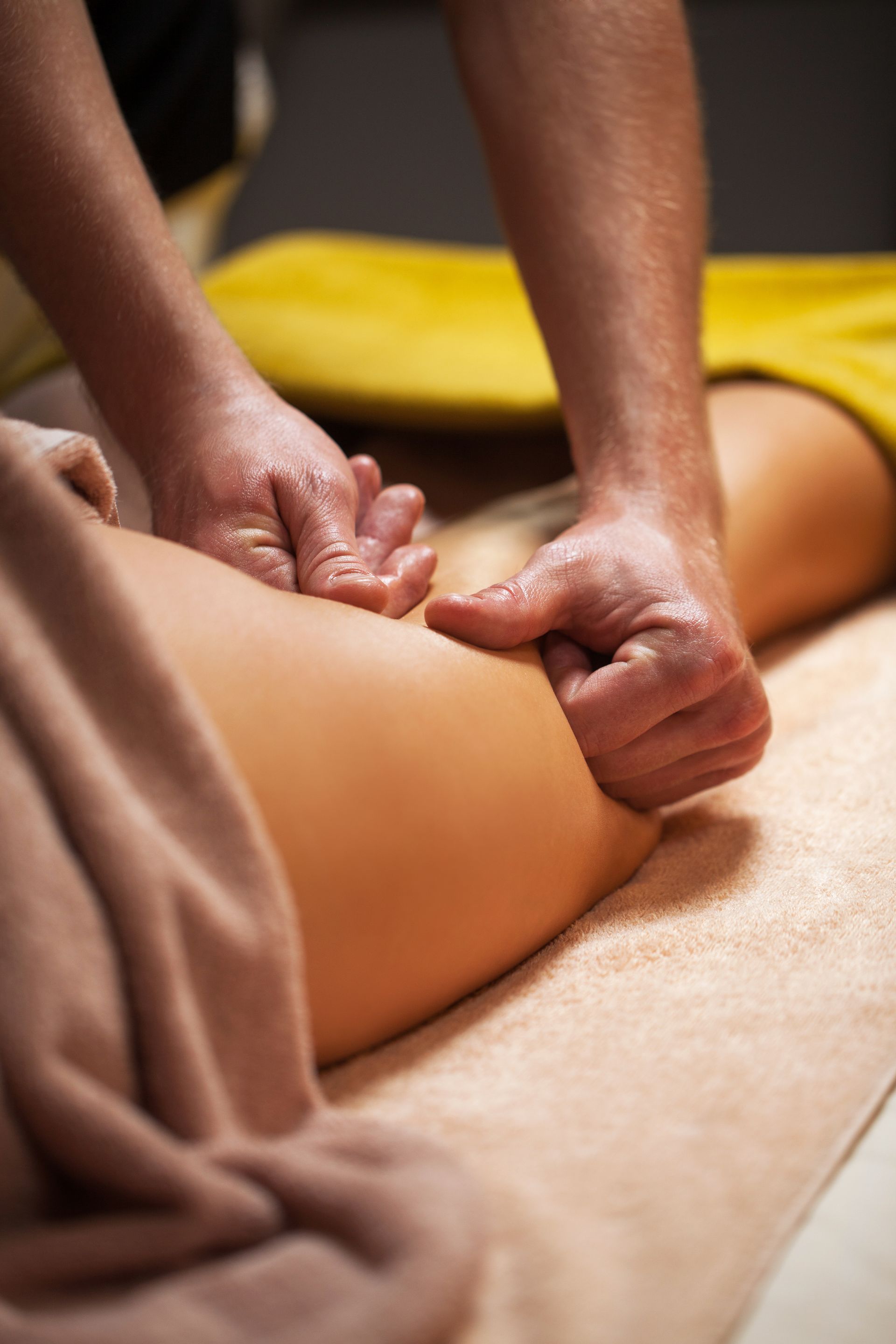 A woman is getting a massage on her leg in a spa.