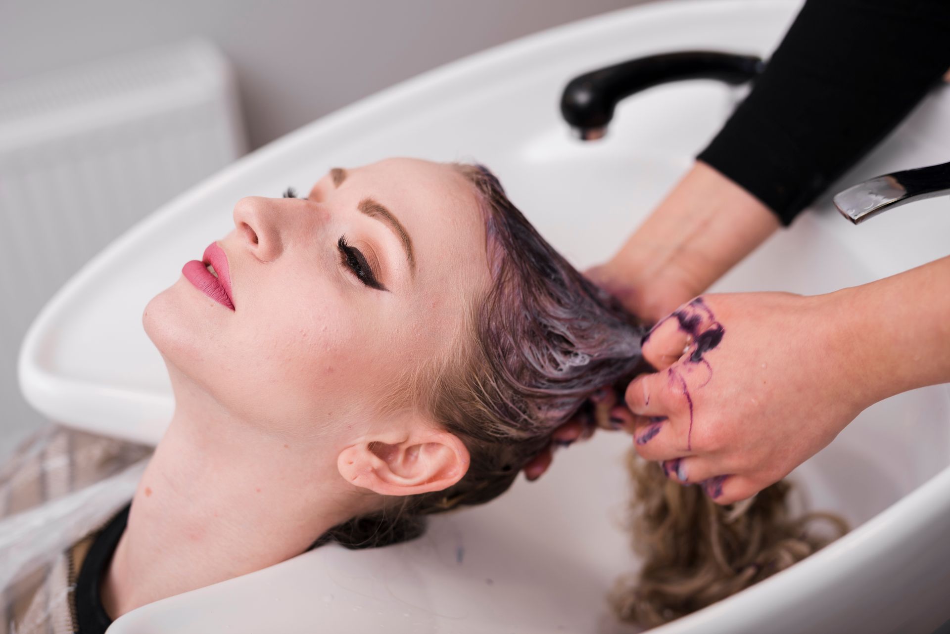 a woman getting her hair washed at a salon