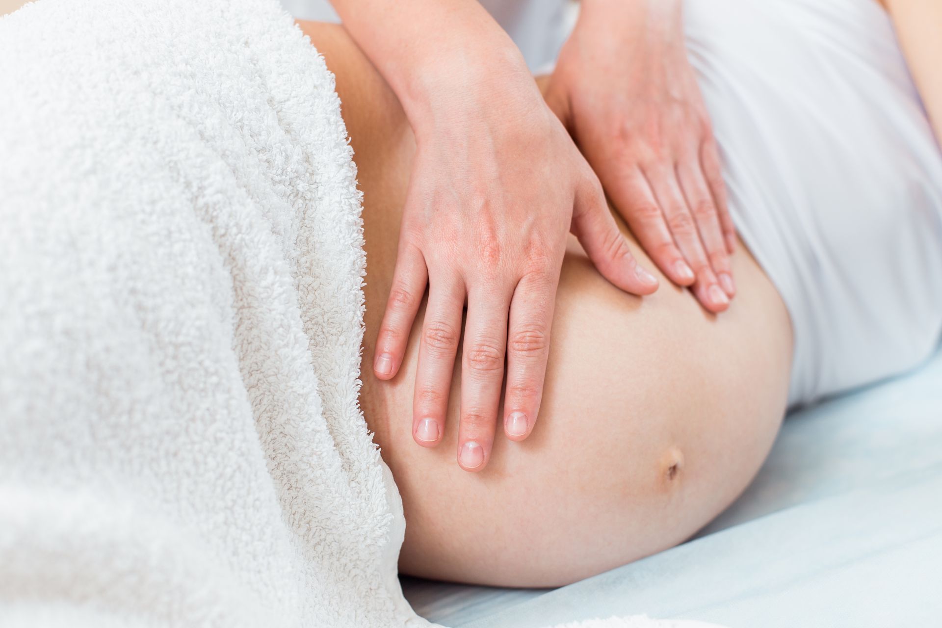 A pregnant woman is getting a massage at a spa.