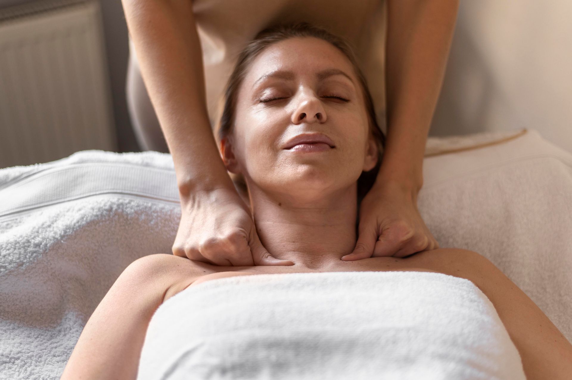 A woman is getting a neck massage at a spa.