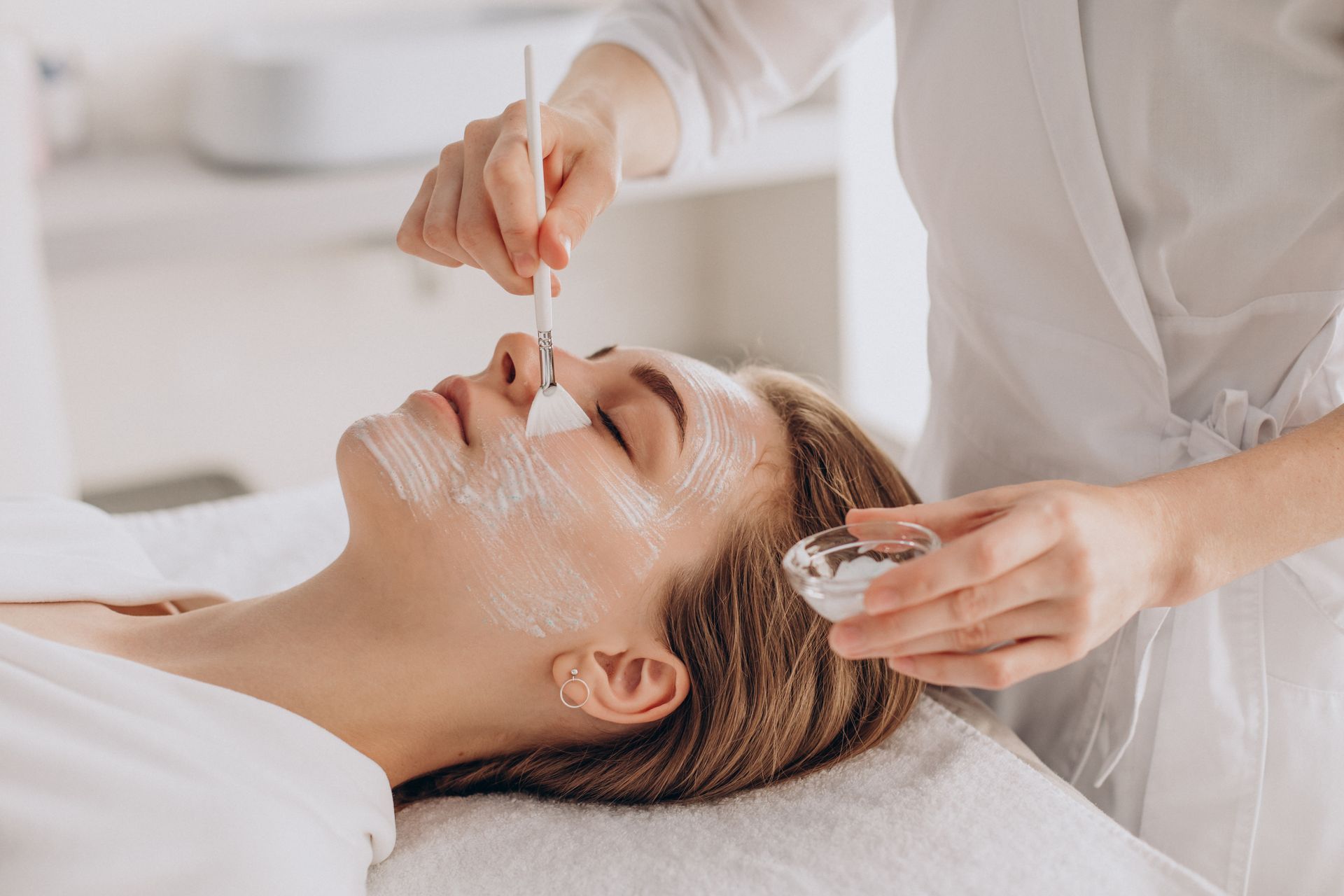 A woman is getting a facial treatment at a spa.