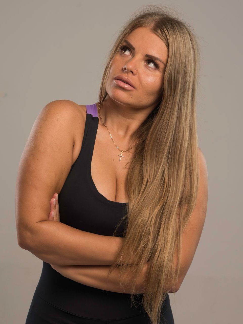 A woman with long hair is looking up with her arms crossed