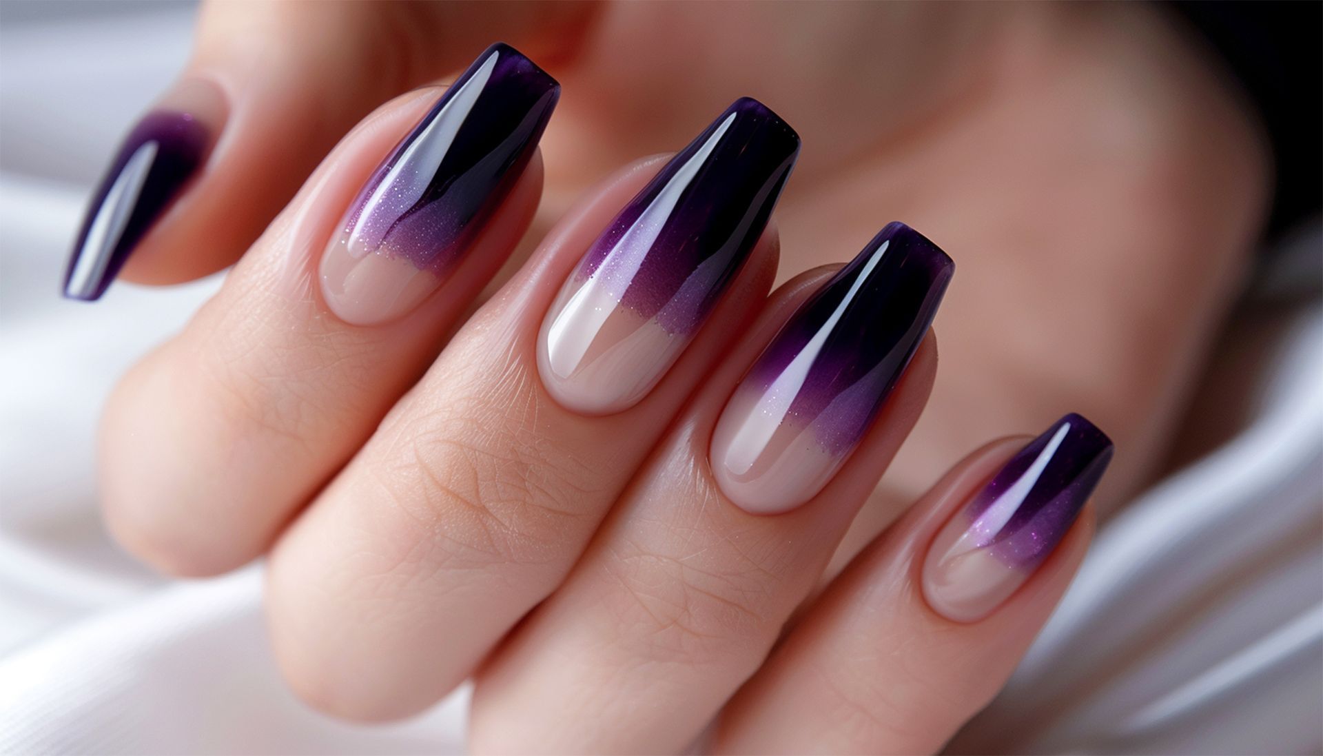 A close up of a woman 's nails with a purple ombre design.