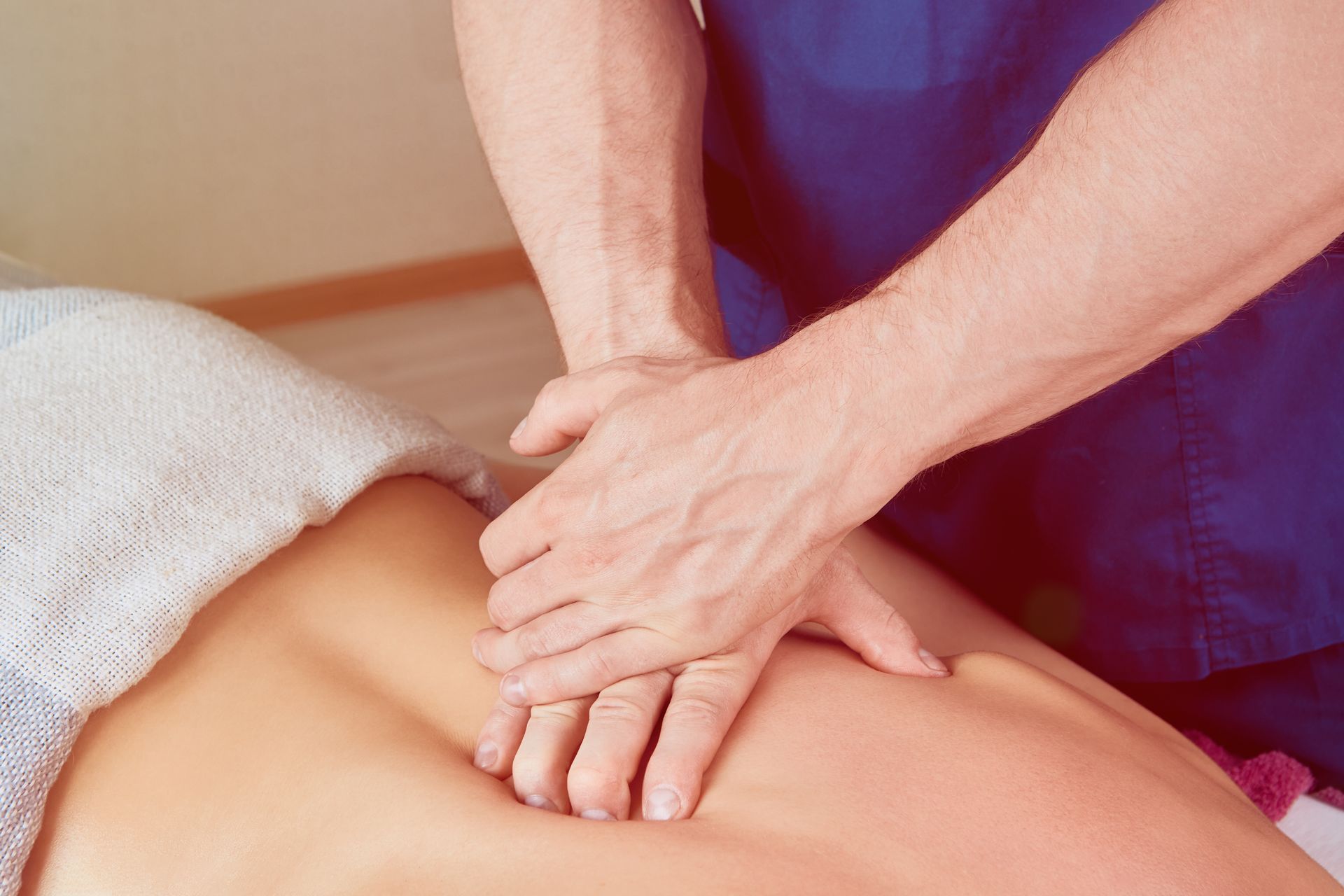 A man is giving a woman a massage on her back.