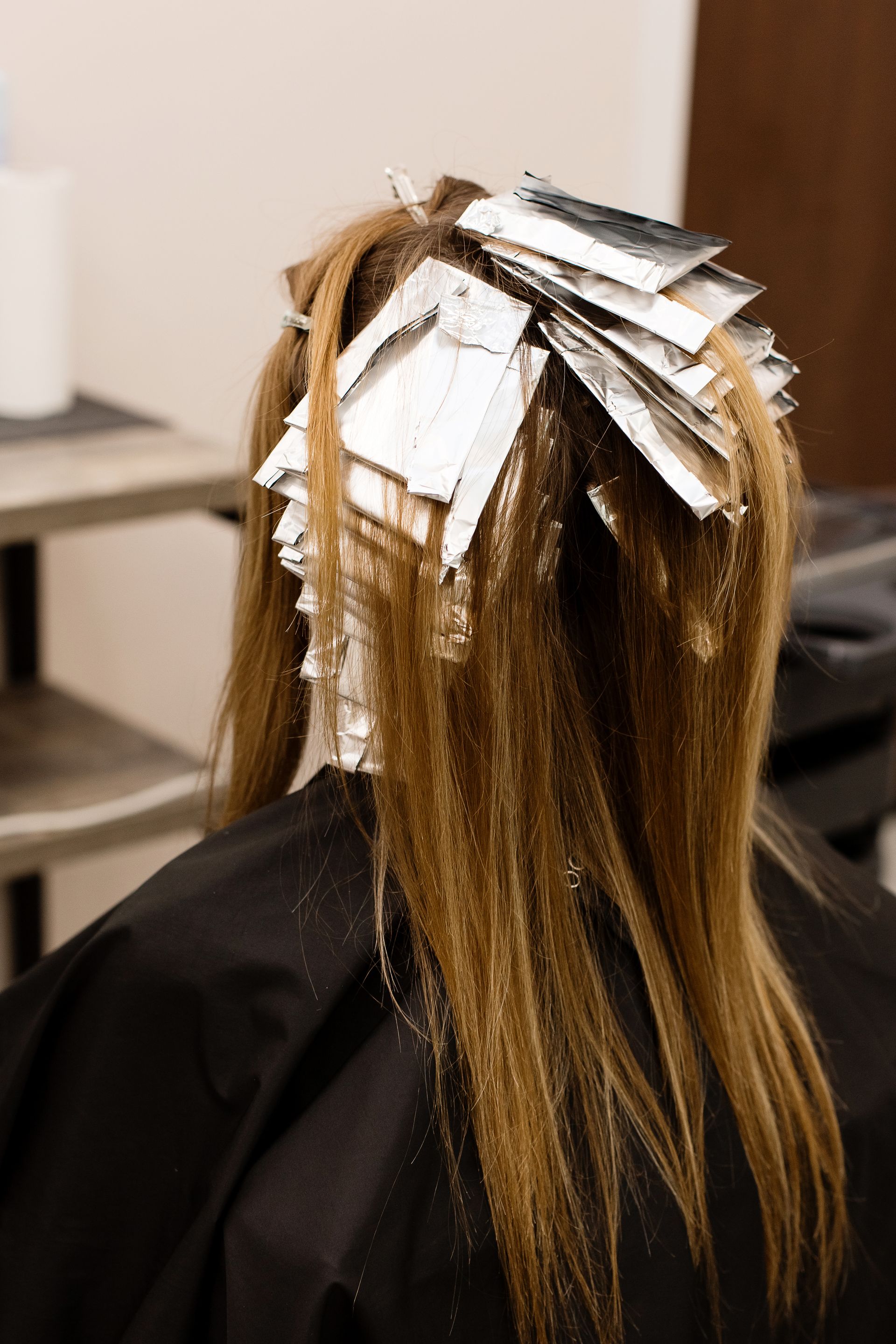 A woman is getting her hair dyed in a salon.