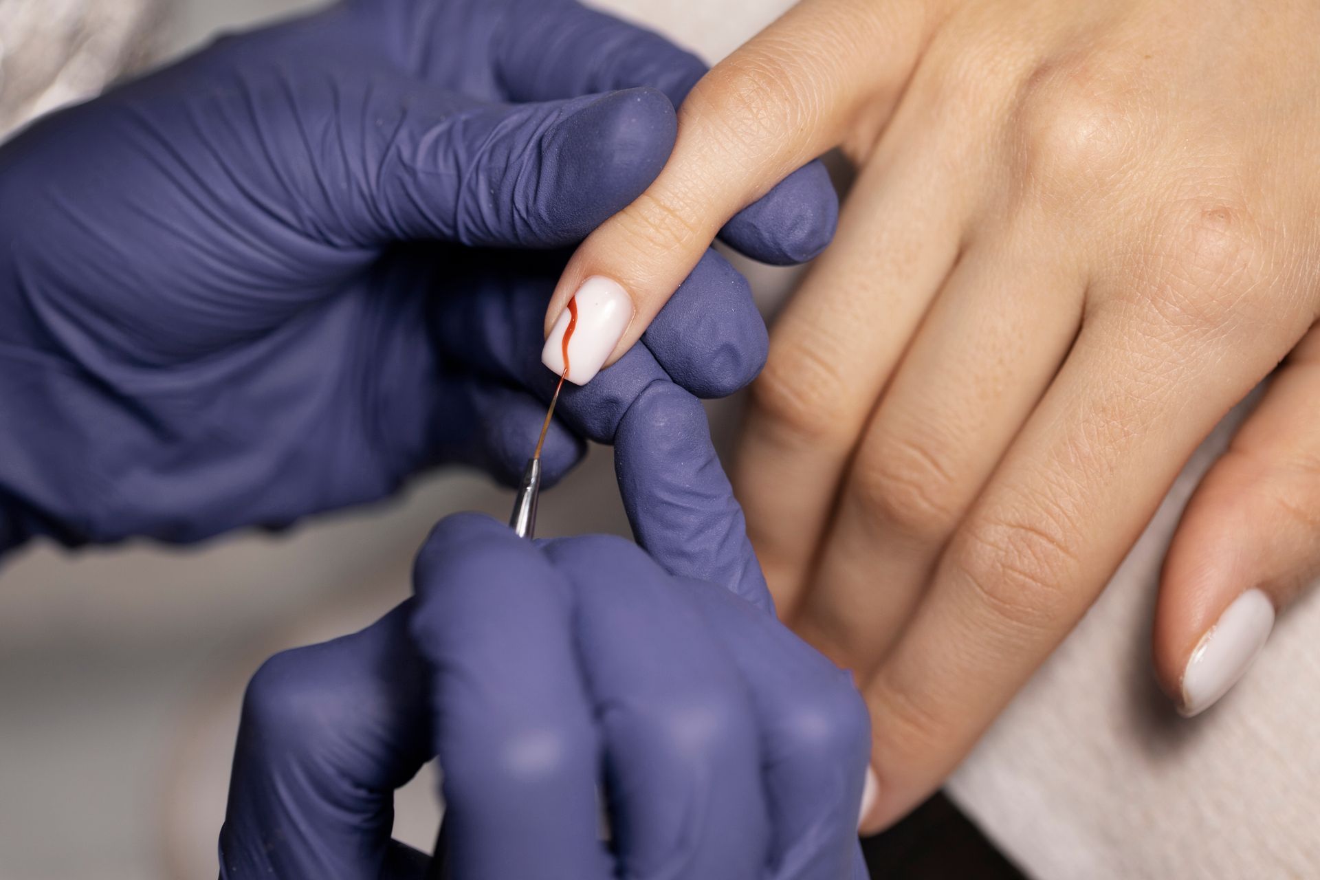 A woman with pink nails is getting her nails done