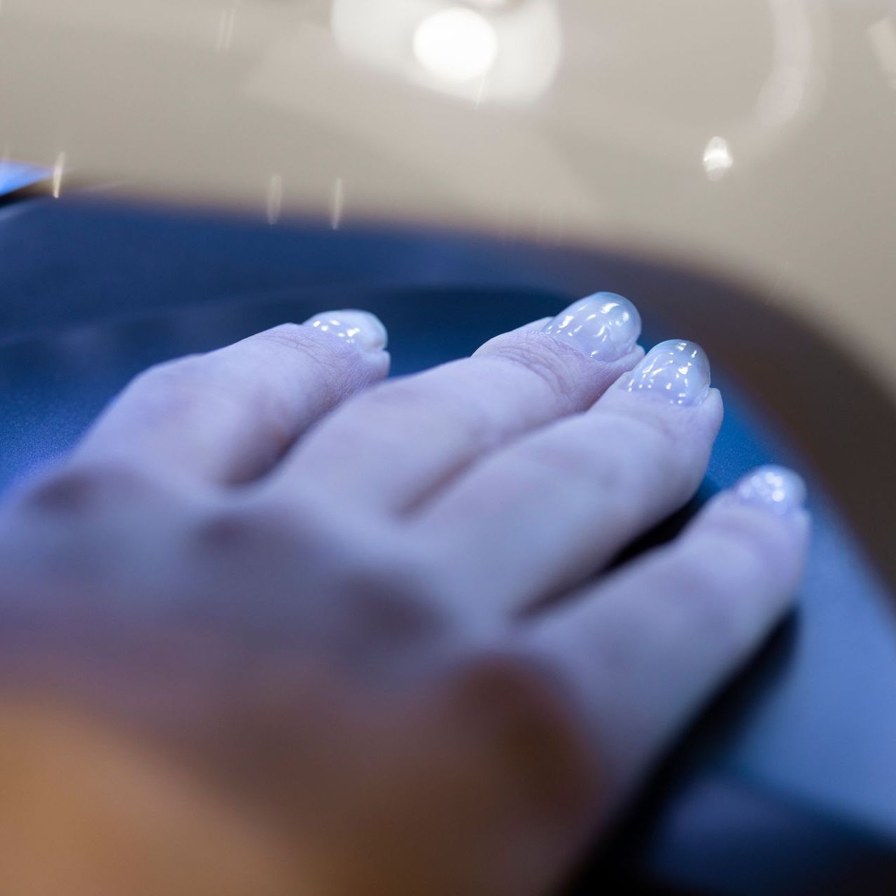 A close up of a person 's hand with white nails