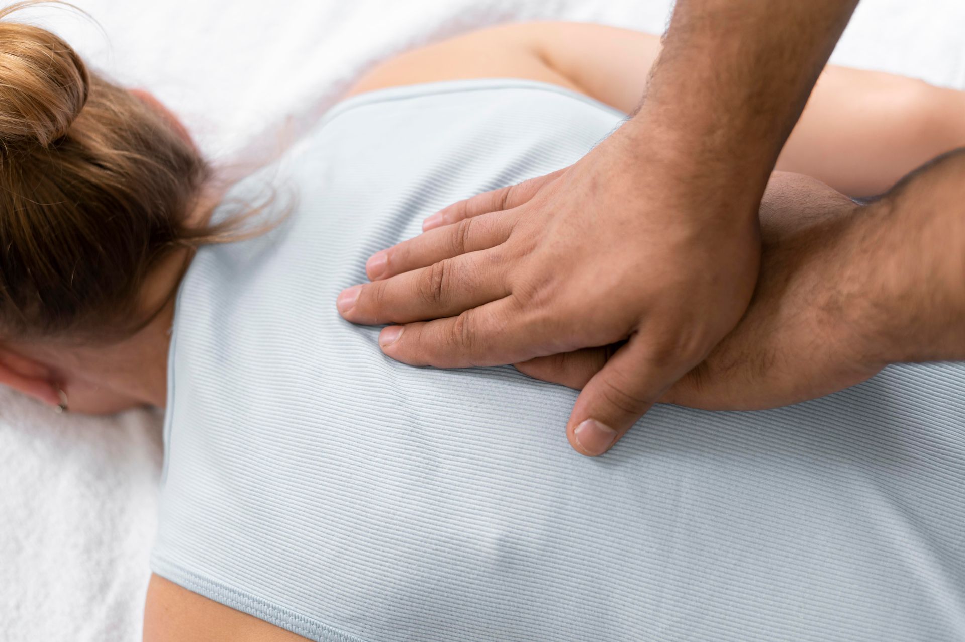 A man is giving a woman a massage on her back.