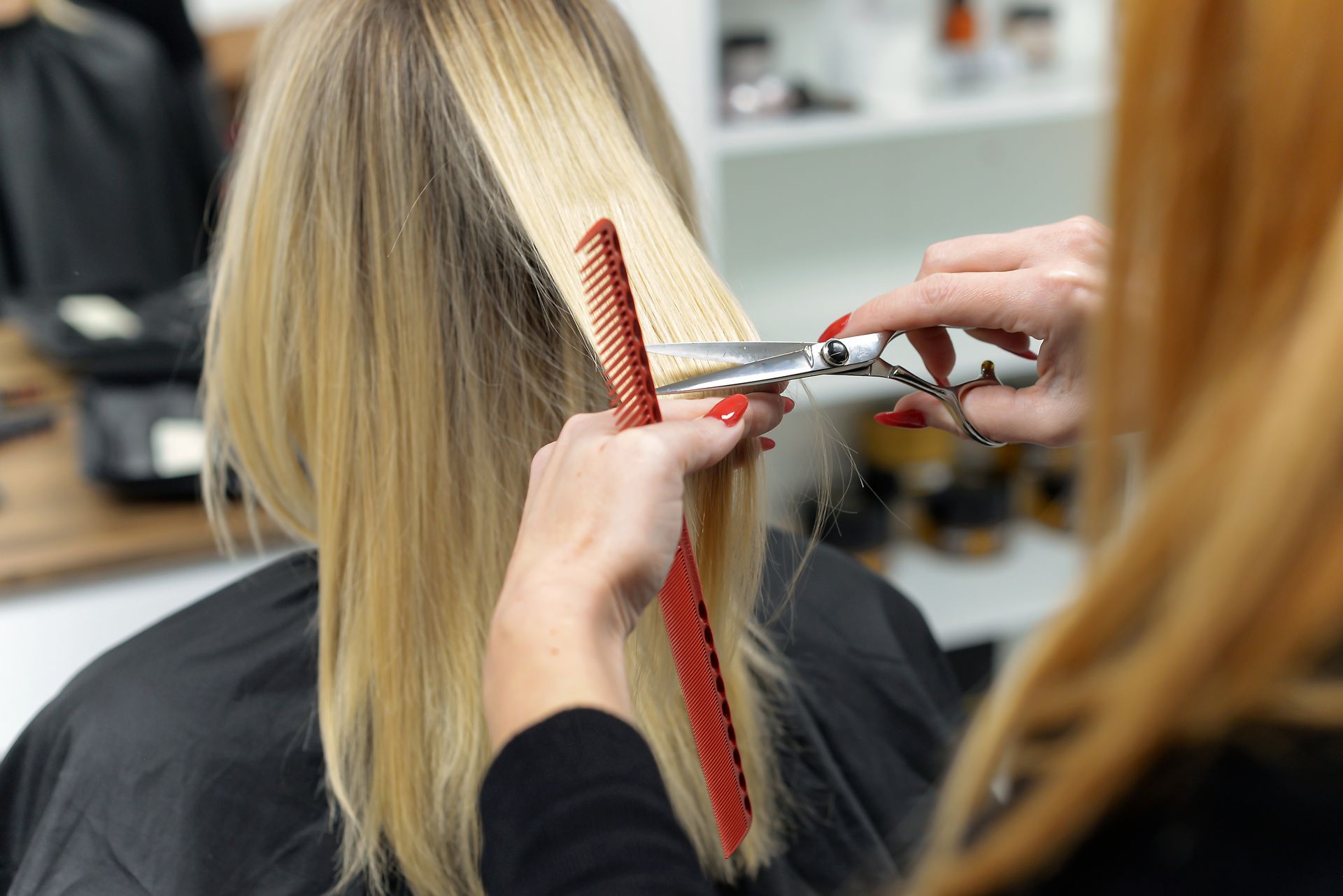 A woman is getting her hair cut by a hairdresser.