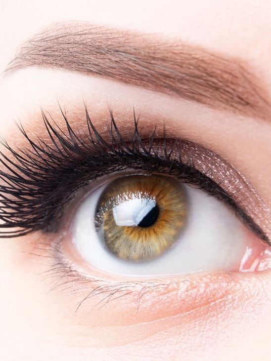 A close up of a woman 's eye with long eyelashes.