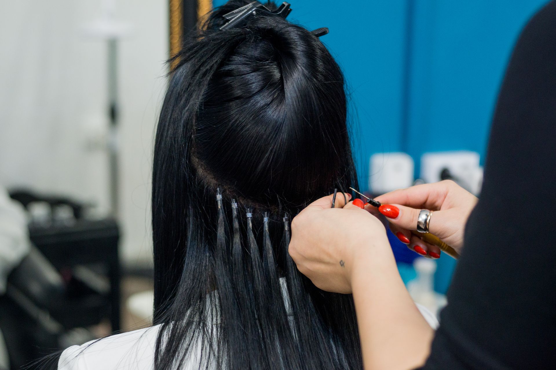 A woman is getting her hair done by a hairdresser in a salon.