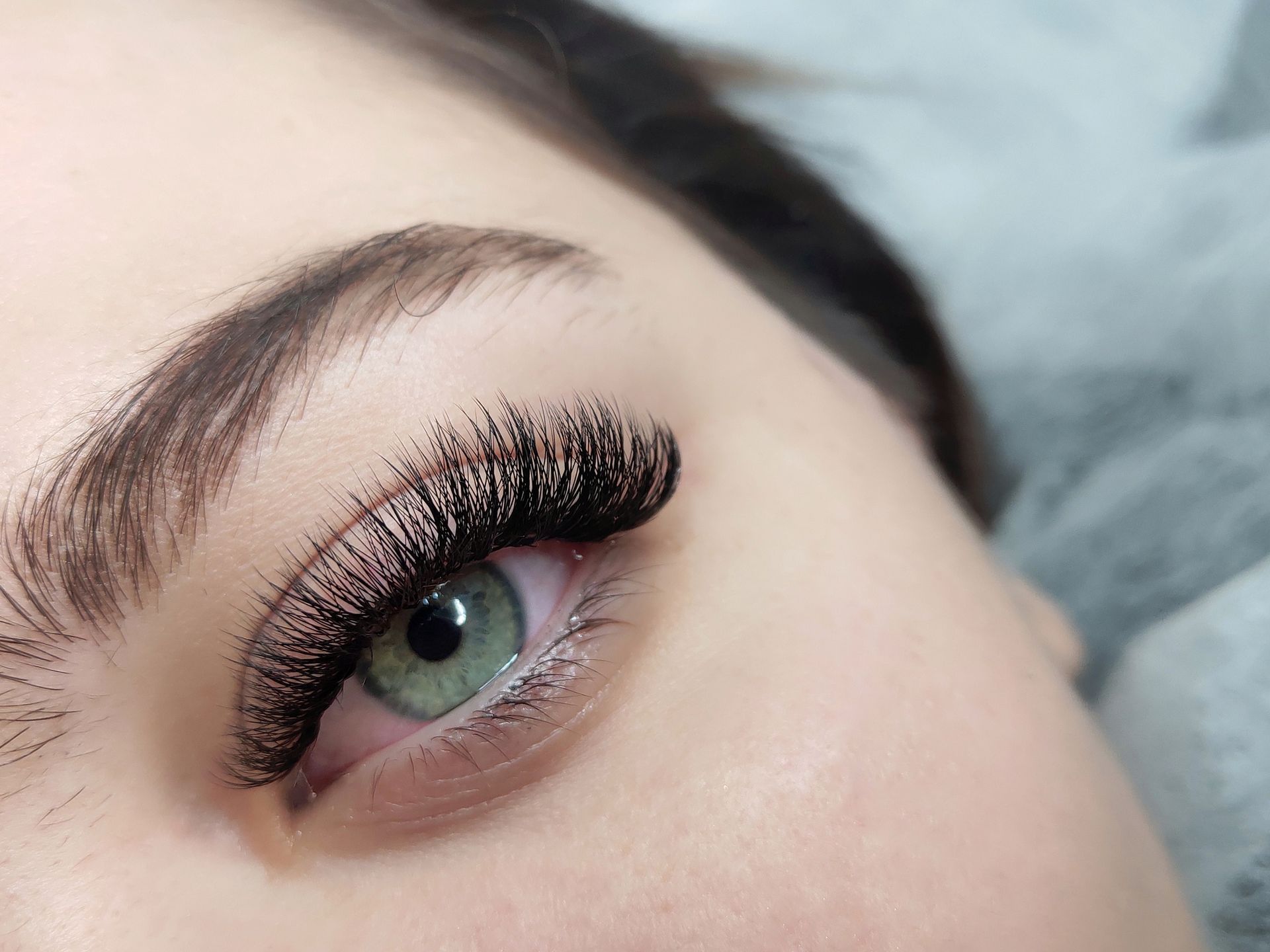 A close up of a woman 's eye with long eyelashes.