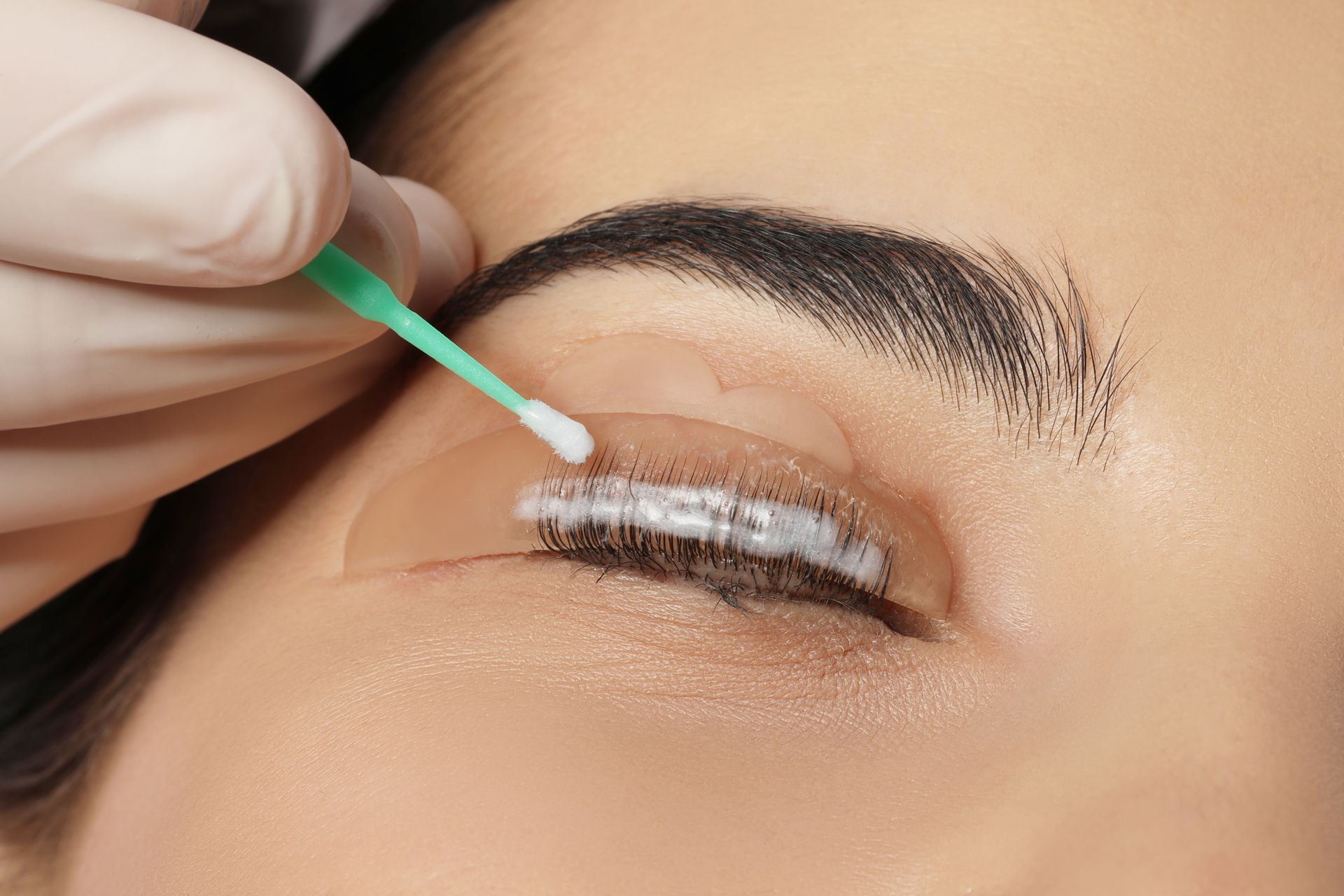 A close up of a woman 's eye being cleaned with a cotton swab.