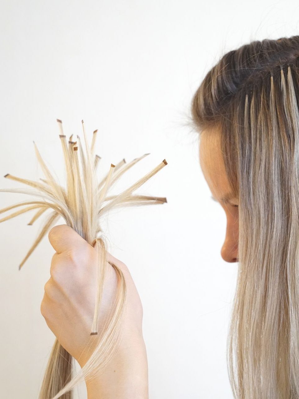 A woman is holding a bunch of sticks in her hand.