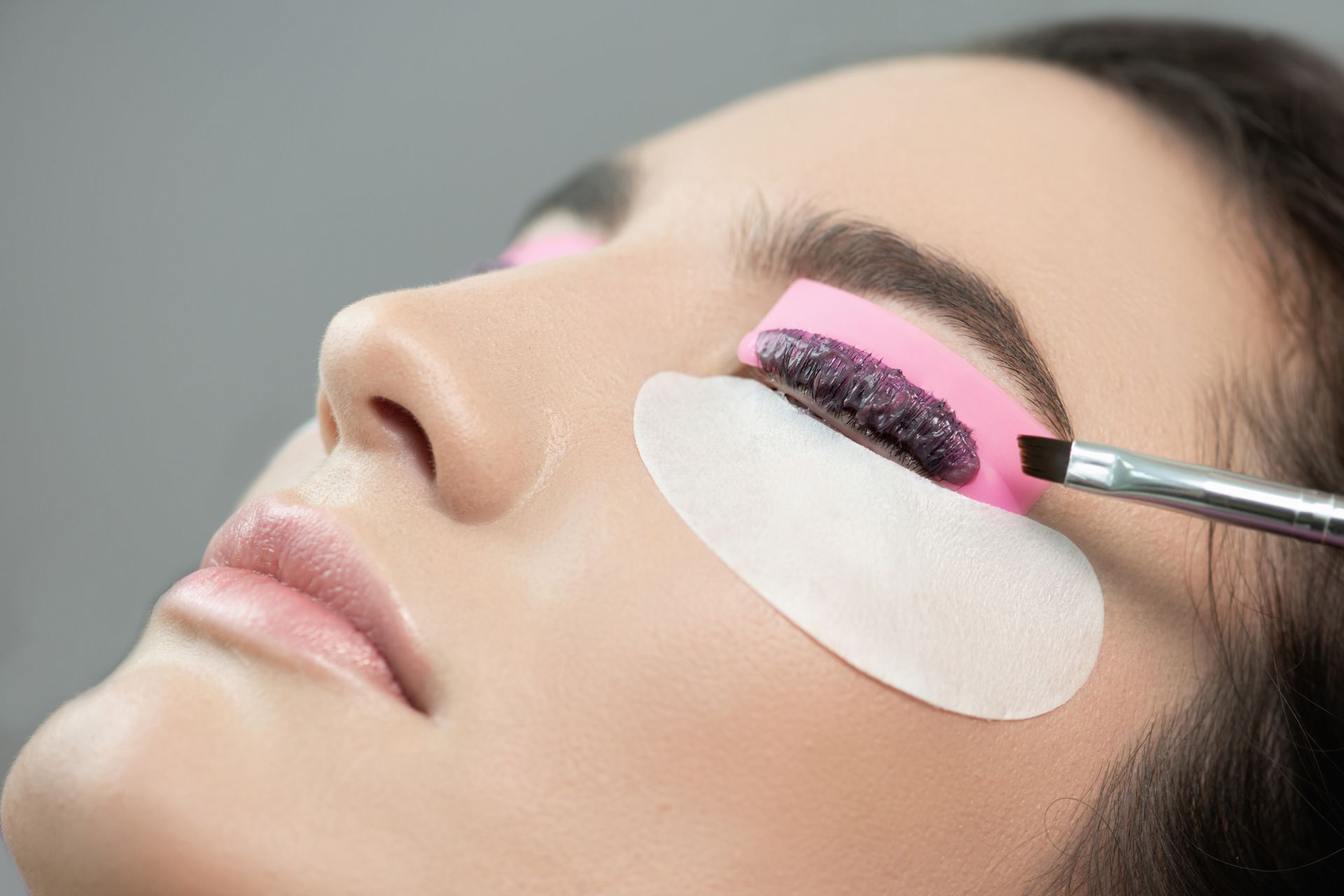 A woman is getting her eyelashes done at a beauty salon.