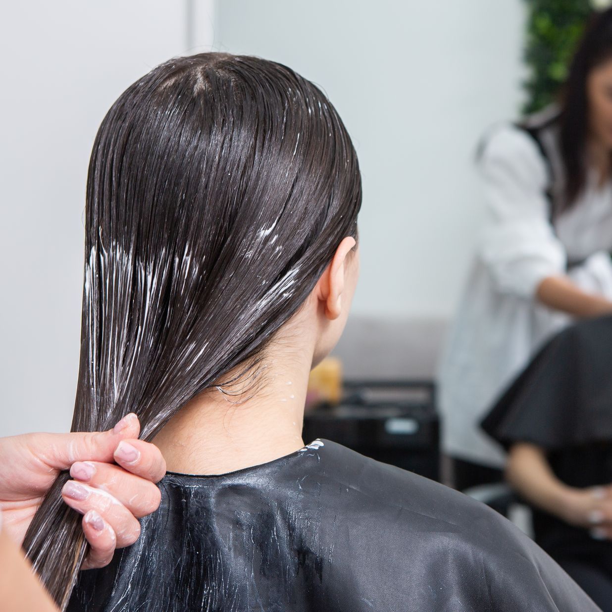 A woman is getting her hair dyed at a salon.