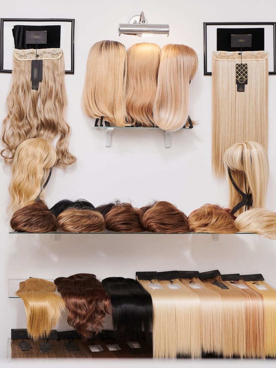 A bunch of wigs are hanging on a wall