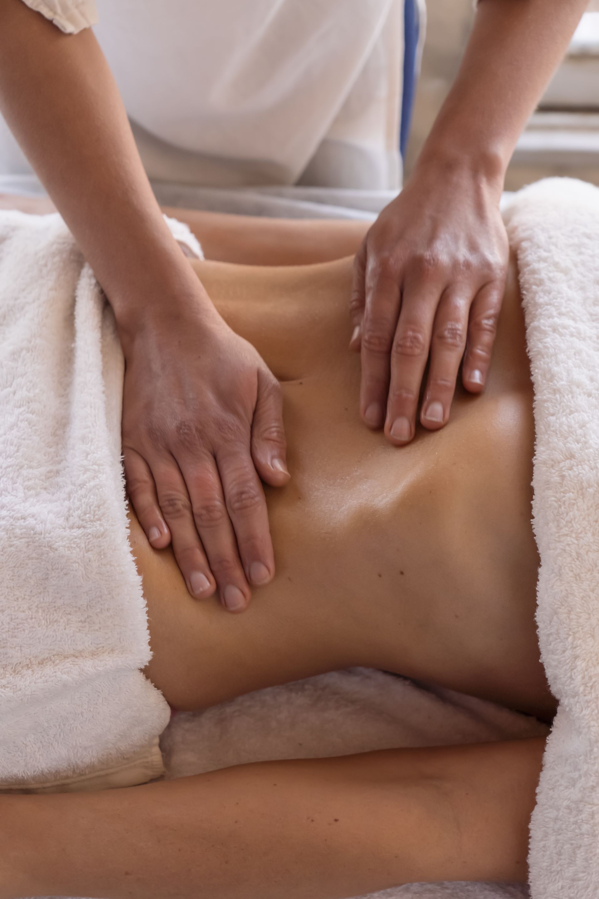 A woman is getting a massage on her stomach in a spa.