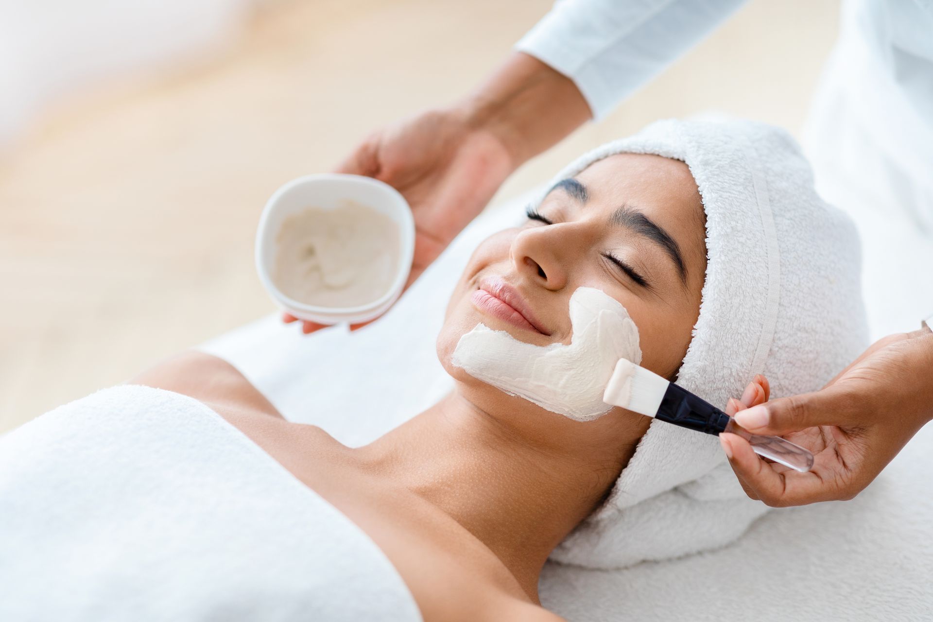 A woman is getting a facial treatment at a spa.