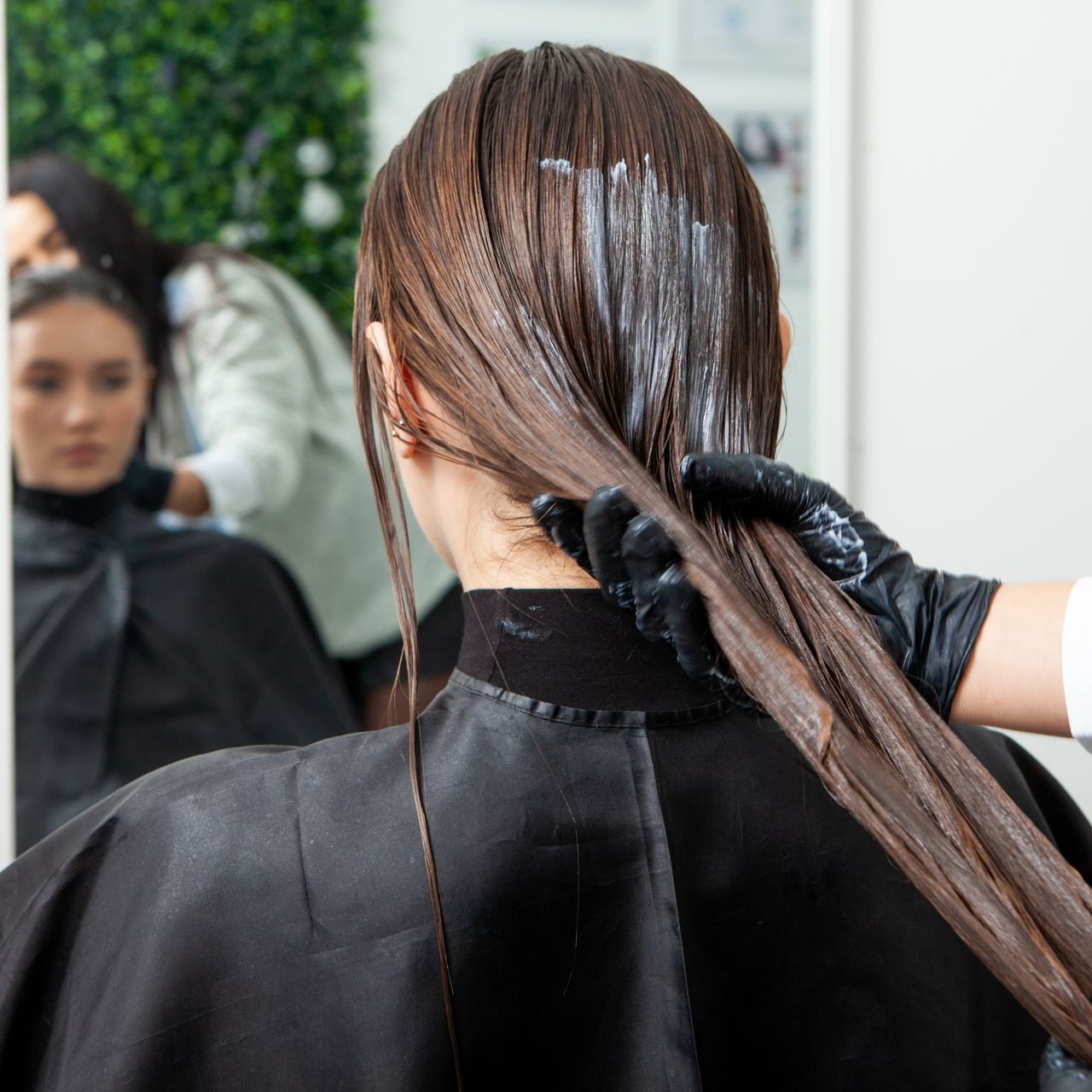 A woman is getting her hair dyed in a salon.