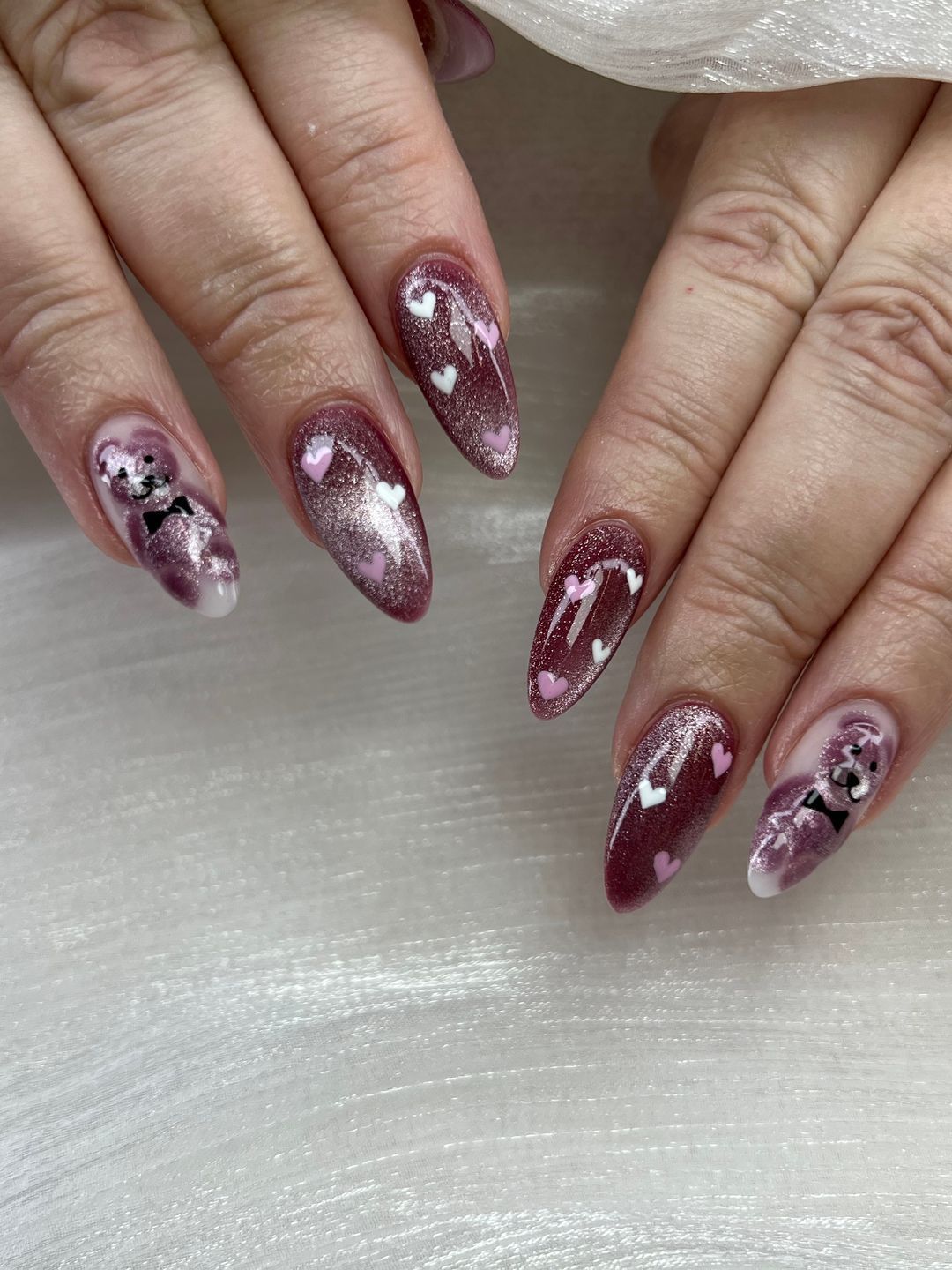 A close up of a woman 's nails with a purple design on them.