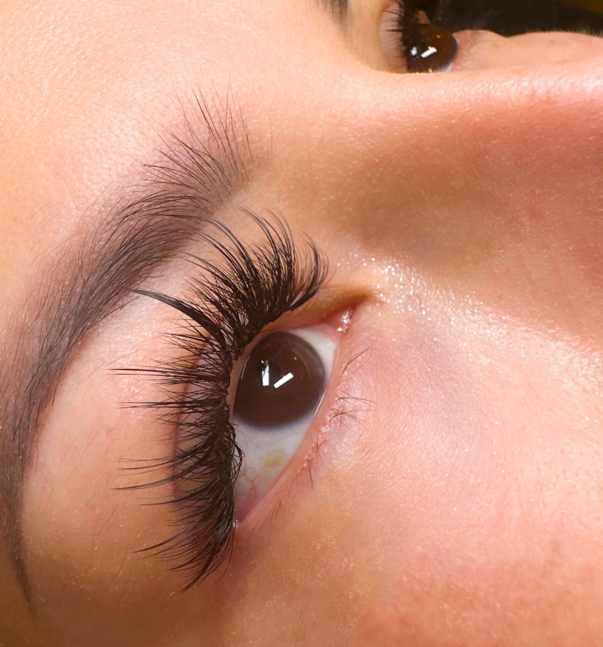 A close up of a woman 's eye with long eyelashes.