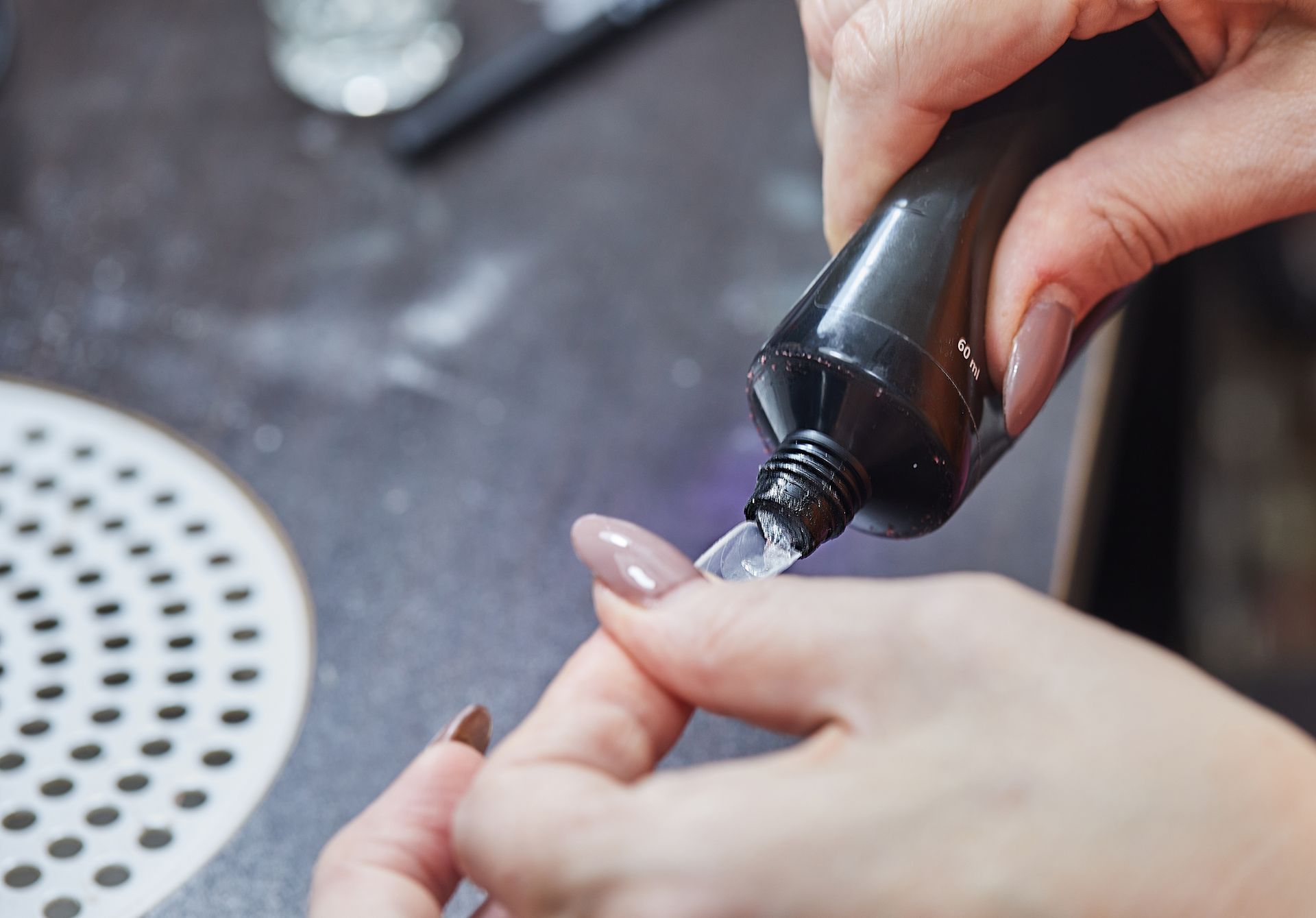 A woman is applying nail polish to her nails.