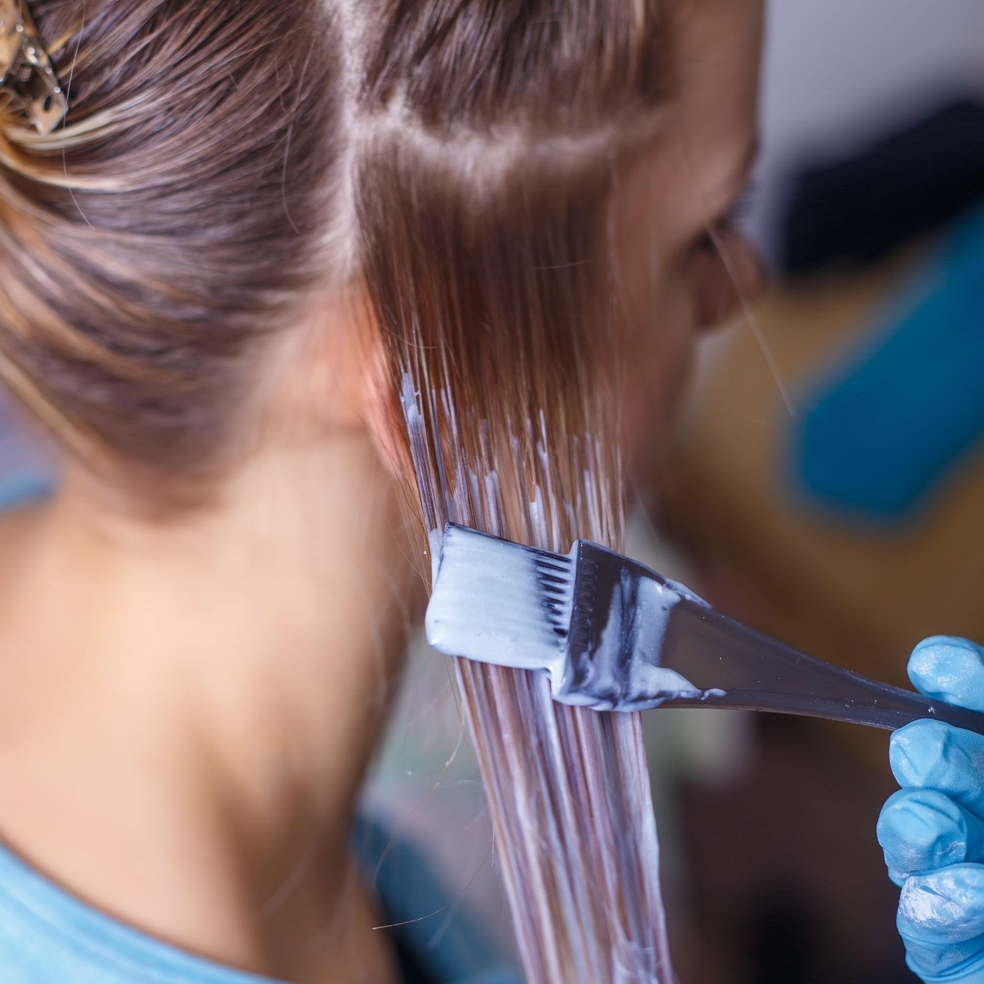 A woman is getting her hair dyed in a salon.