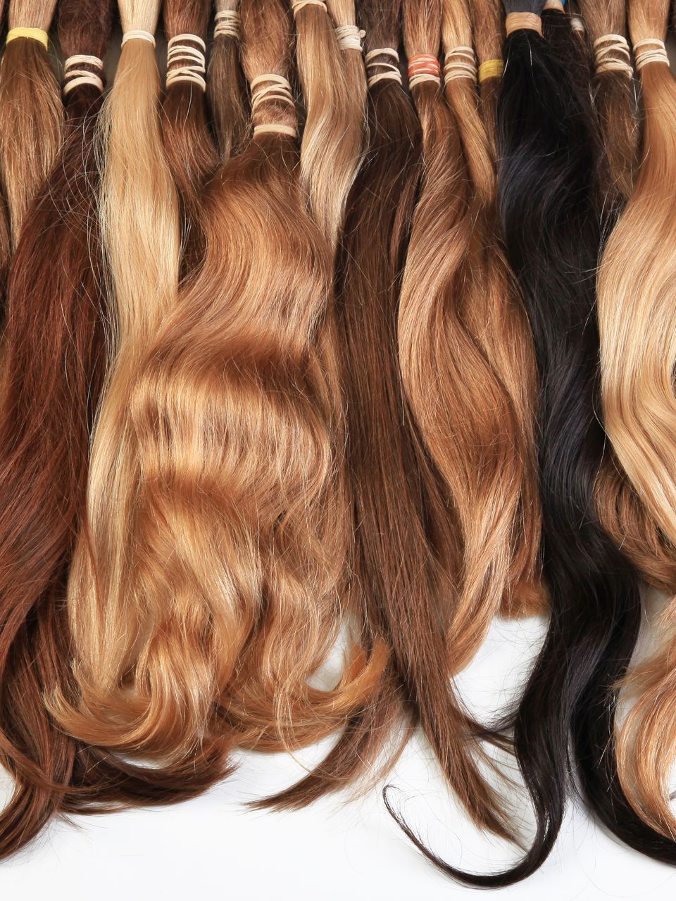 A bunch of different colored hair extensions are sitting on a table.