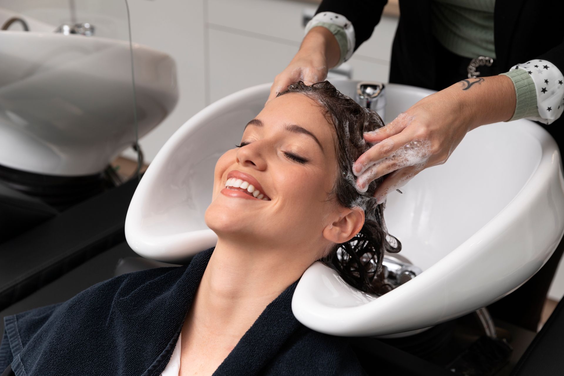 A woman is getting her hair washed at a salon.