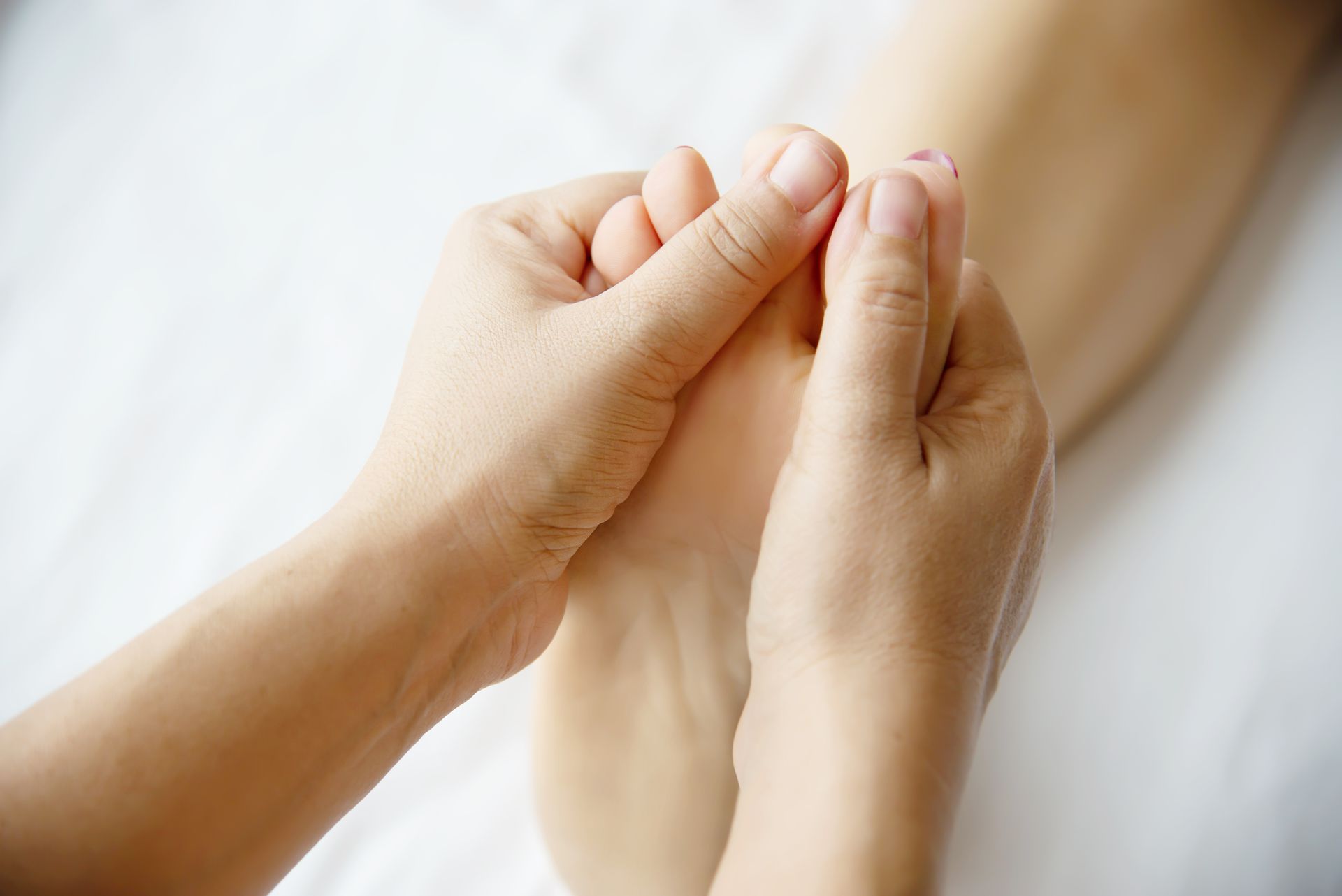 A person is giving a foot massage to another person.