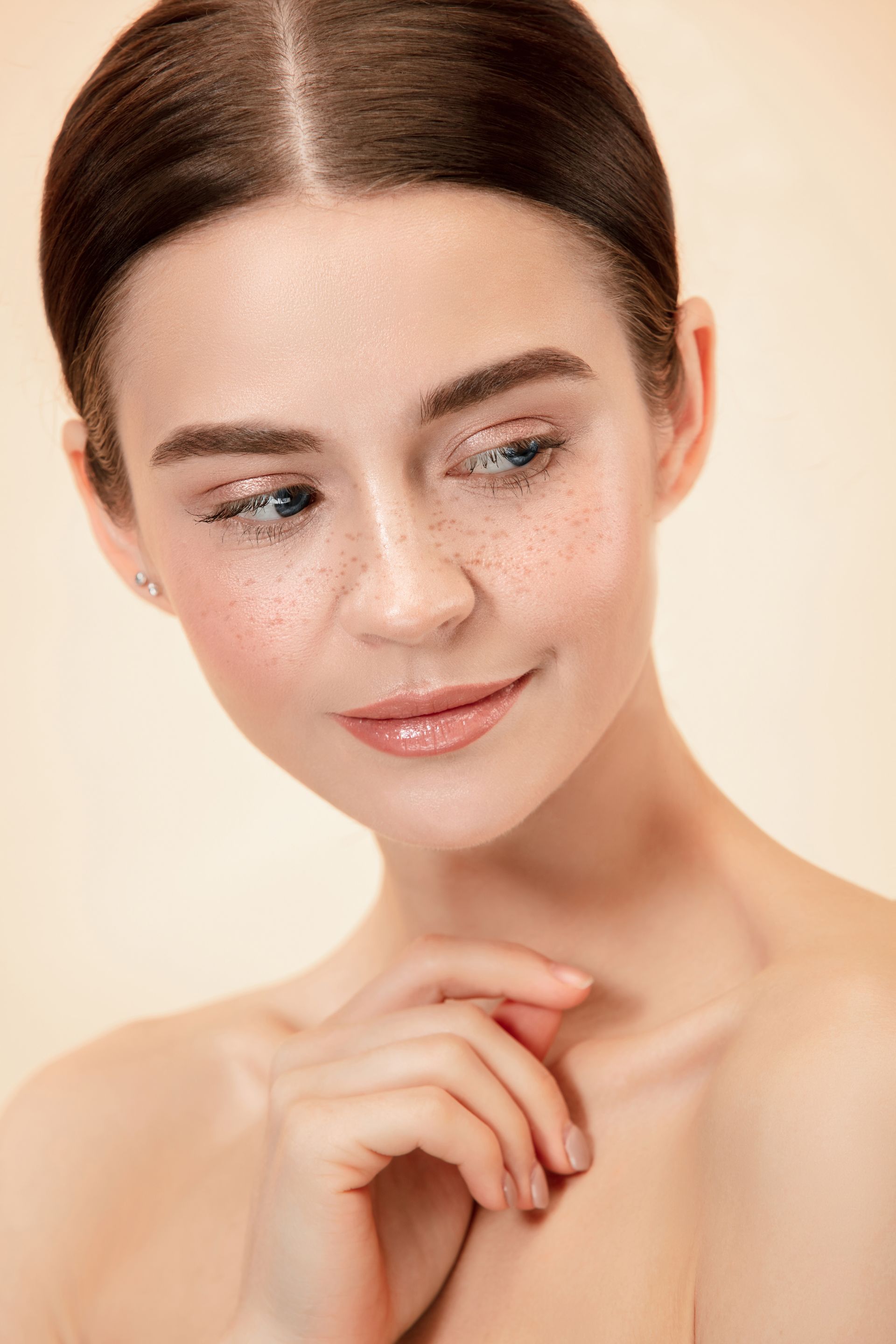 A close up of a woman 's face with her hand on her chin.