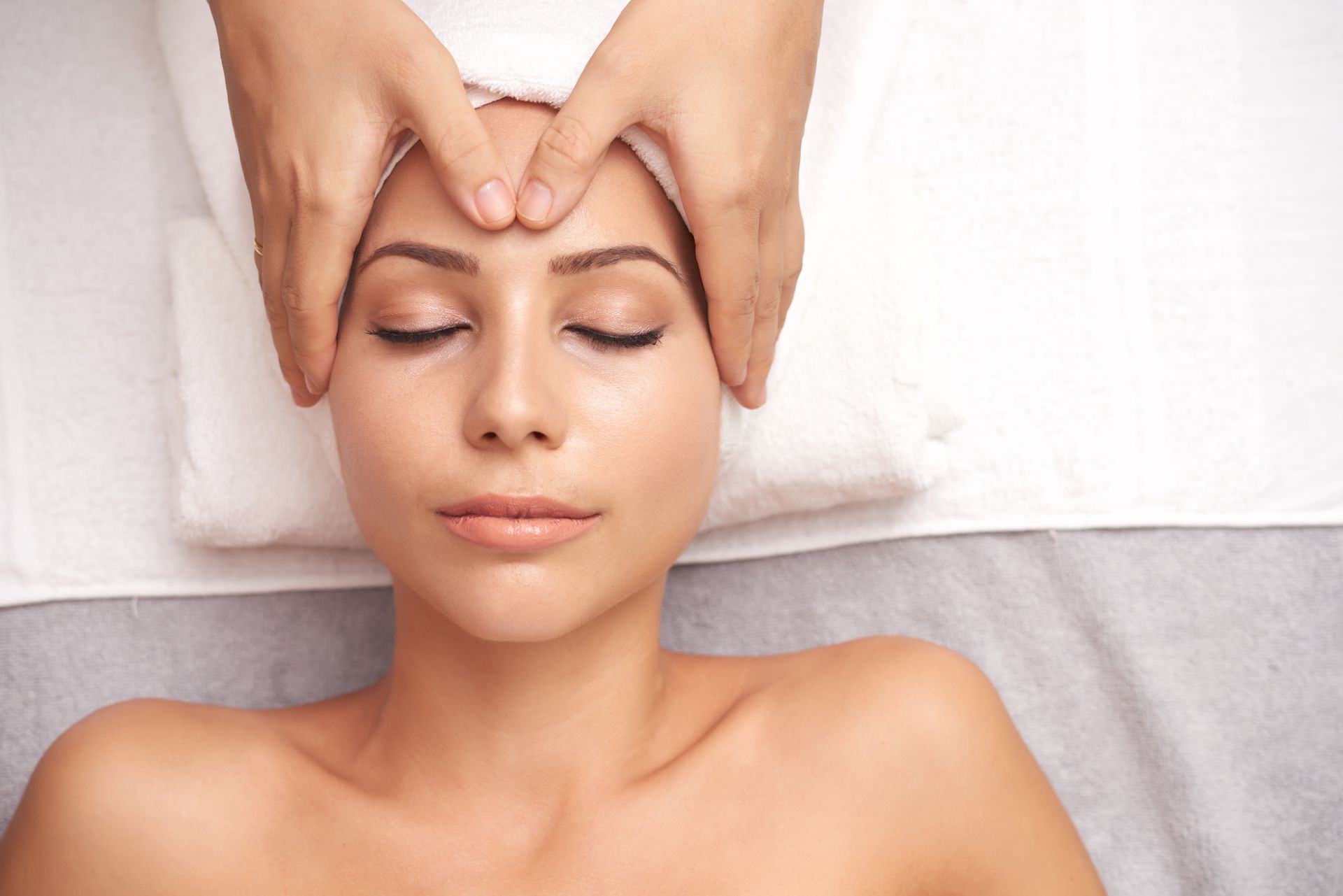 A woman is getting a head massage at a spa.