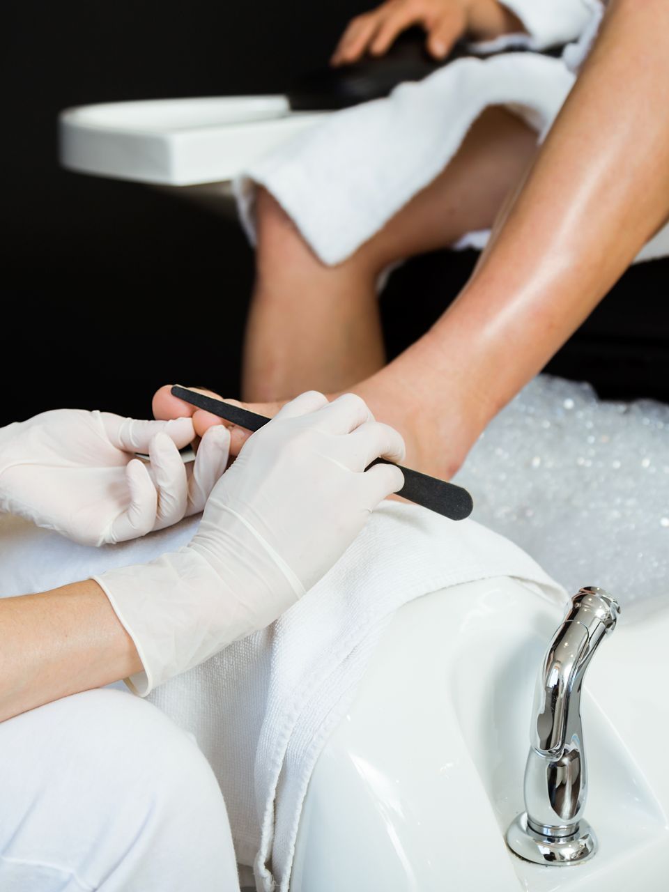 A woman is getting her nails done at a nail salon