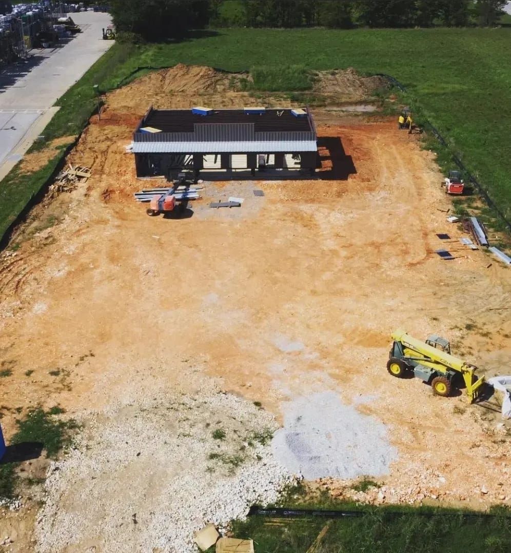 An aerial view of a construction site with a building in the background