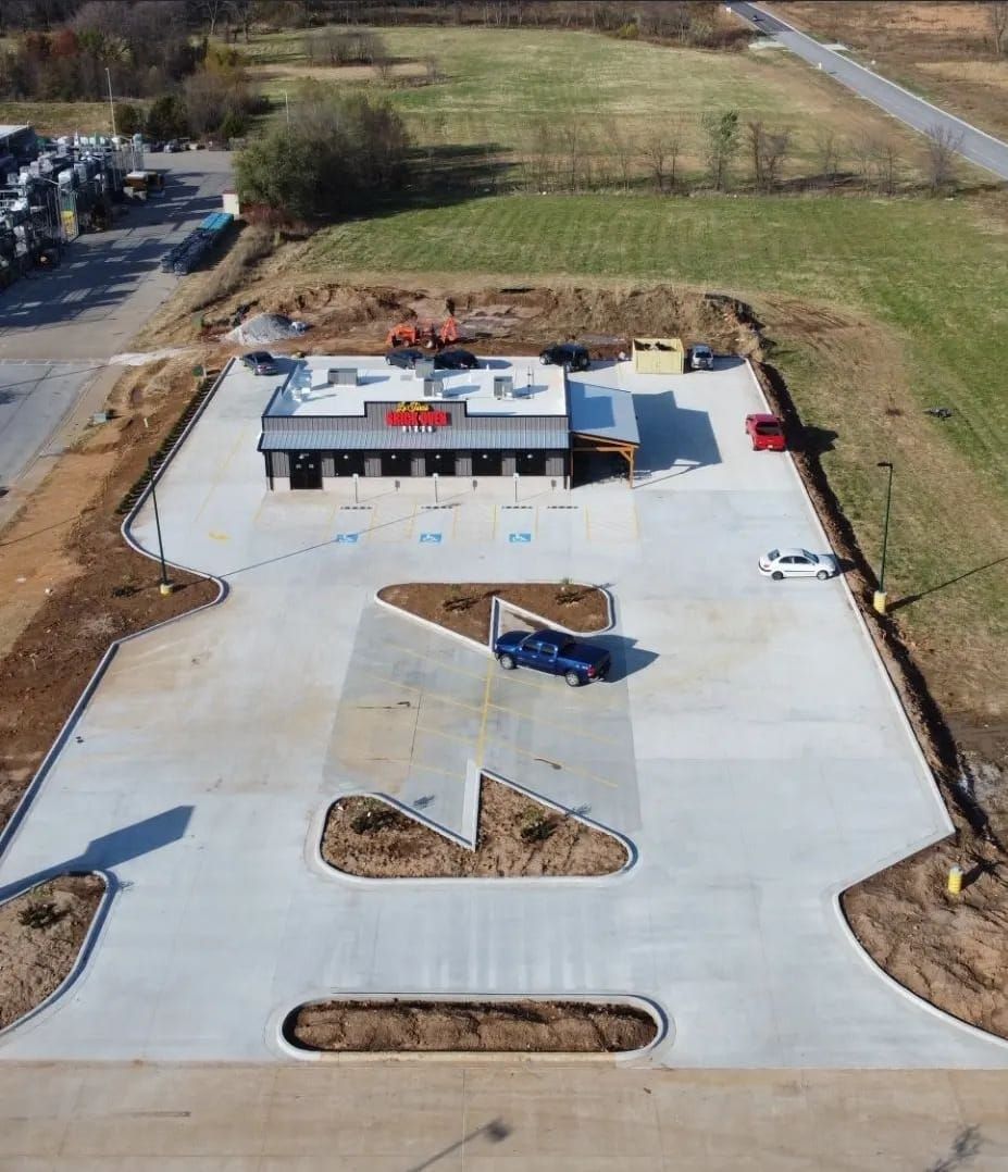 An aerial view of a parking lot with a building in the background