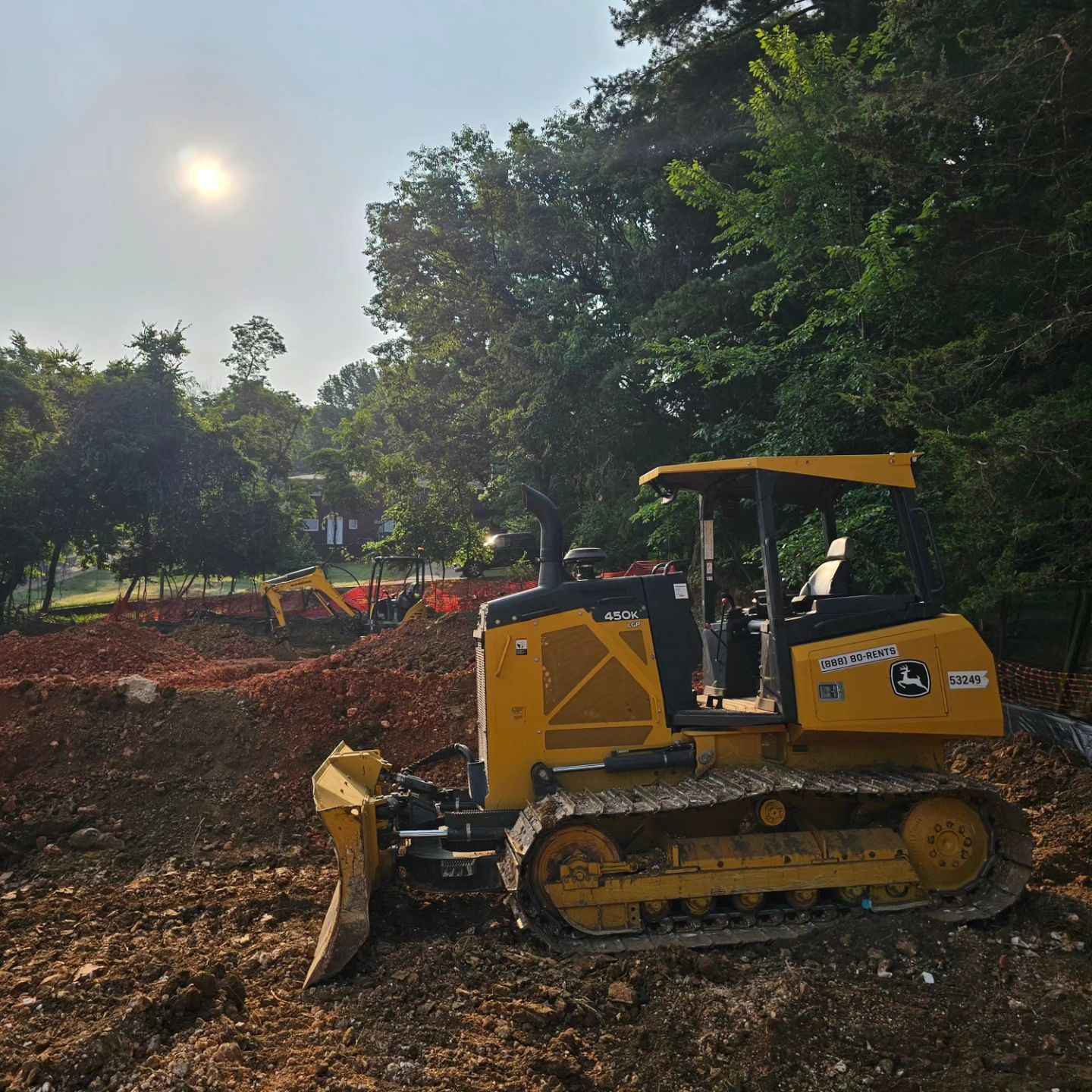 A yellow bulldozer is parked in a dirt field