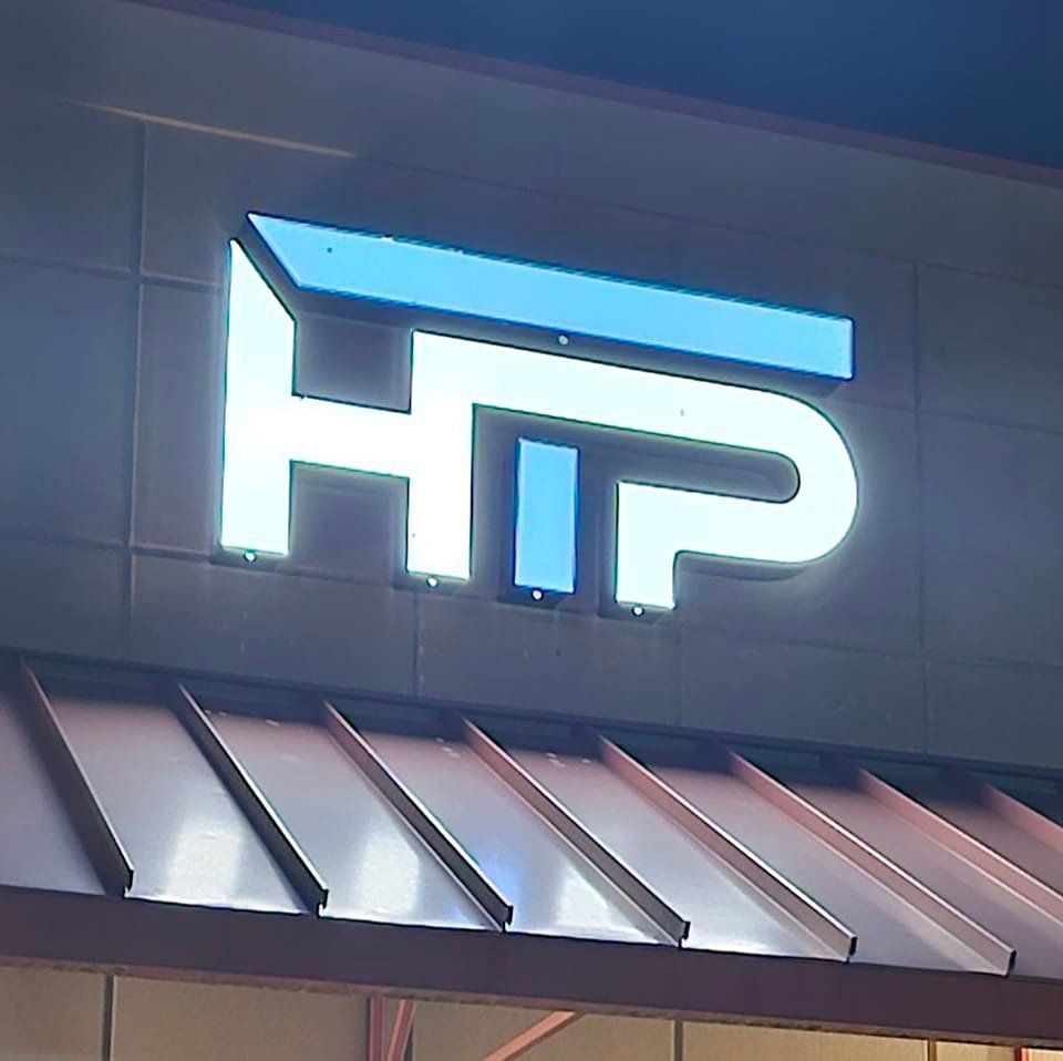 The HTP logo is lit up on the side of a building