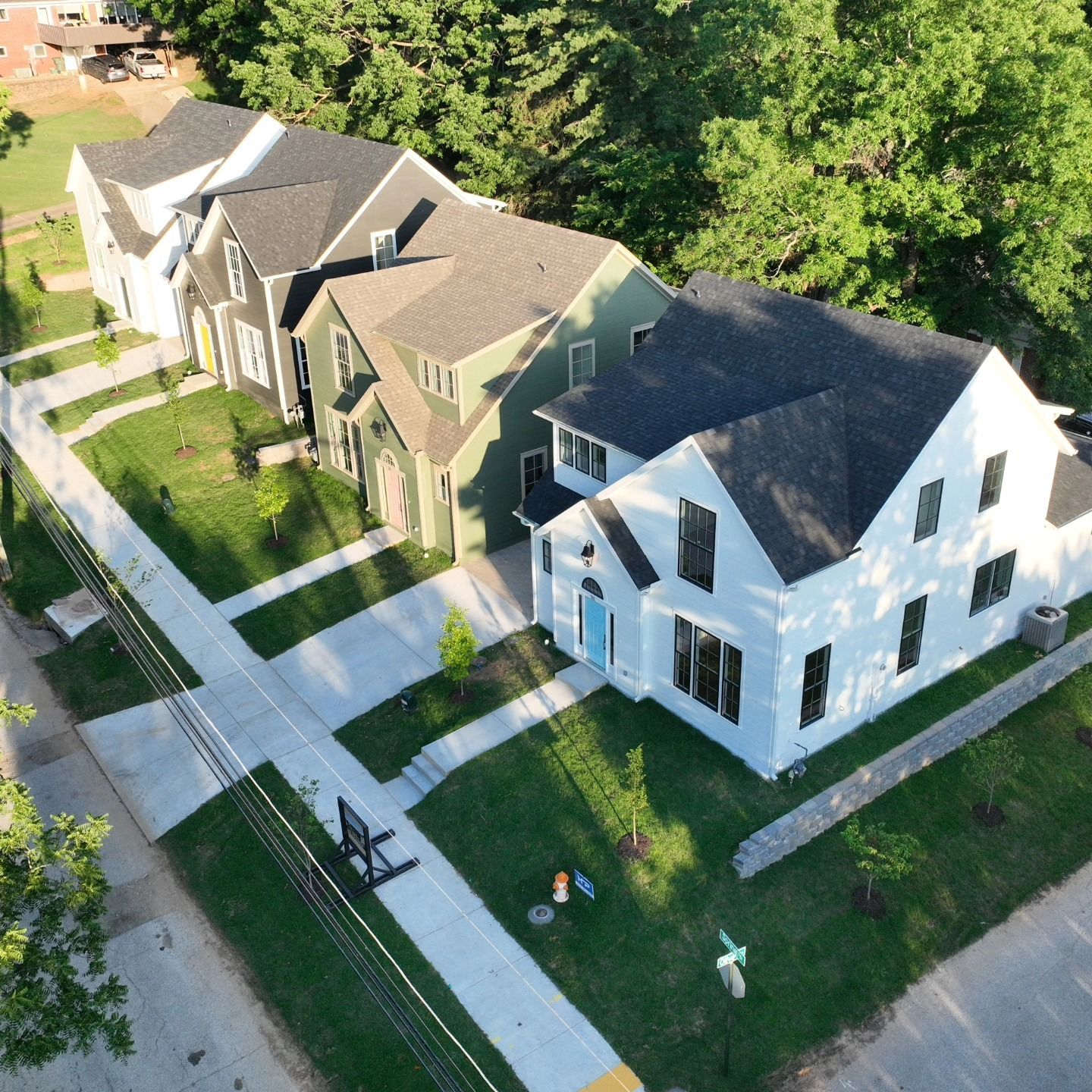 An aerial view of a row of houses with trees in the background