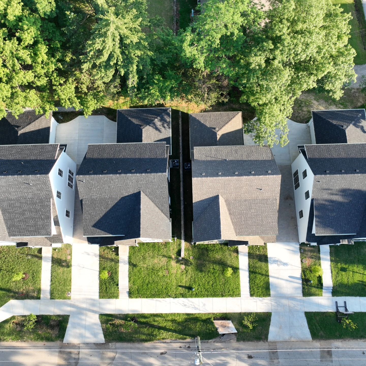 An aerial view of a row of houses with black roofs