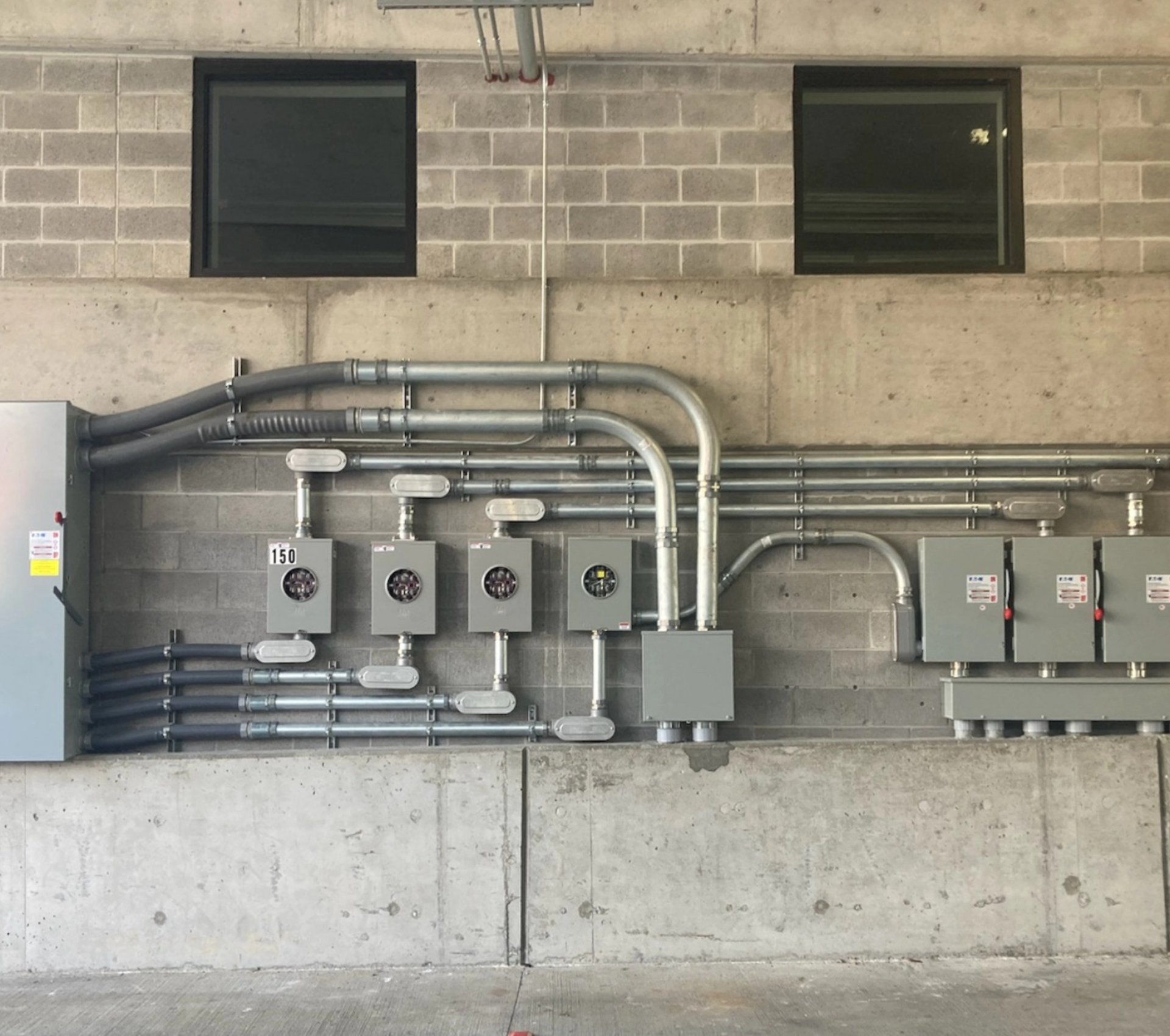 A brick wall with a bunch of electrical boxes on it