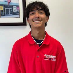 Gabby Melendez is wearing a red polo shirt and smiling.