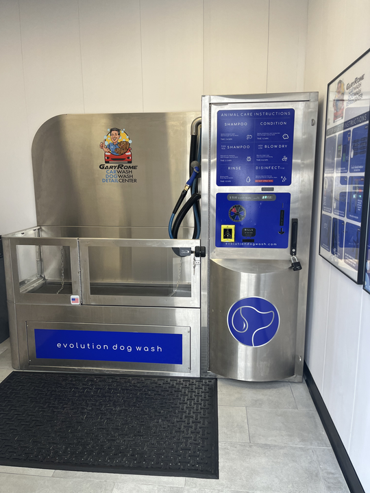A stainless steel dog wash machine is sitting in a room.