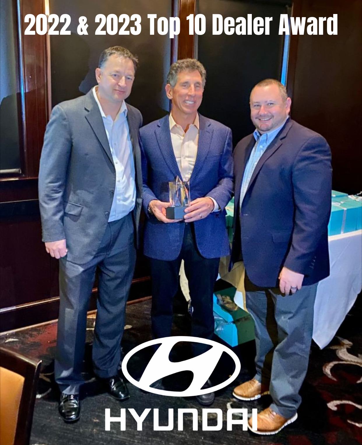 Three men standing next to each other in front of a hyundai logo