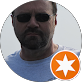 A man with a beard and sunglasses is in a circle with an orange star.