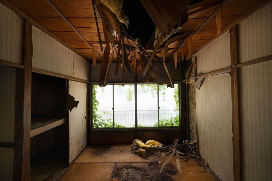 A room with a broken ceiling and a window.