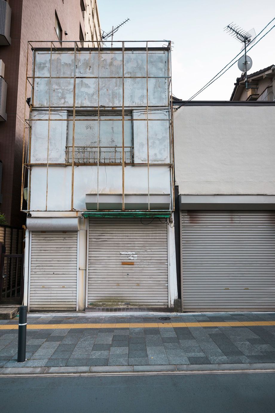 A building with shutters on the side of it is being demolished.